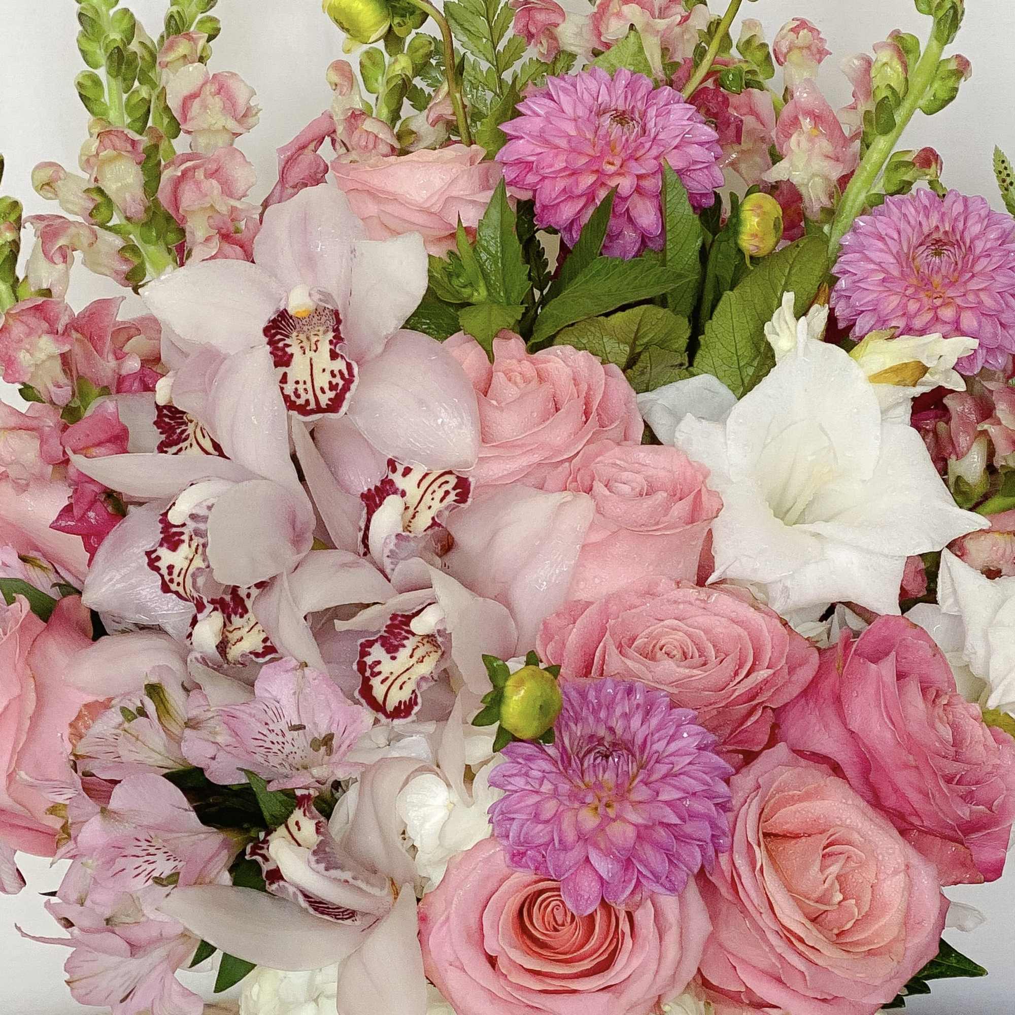 Pink and white bouquet with roses, orchids, and dahlias