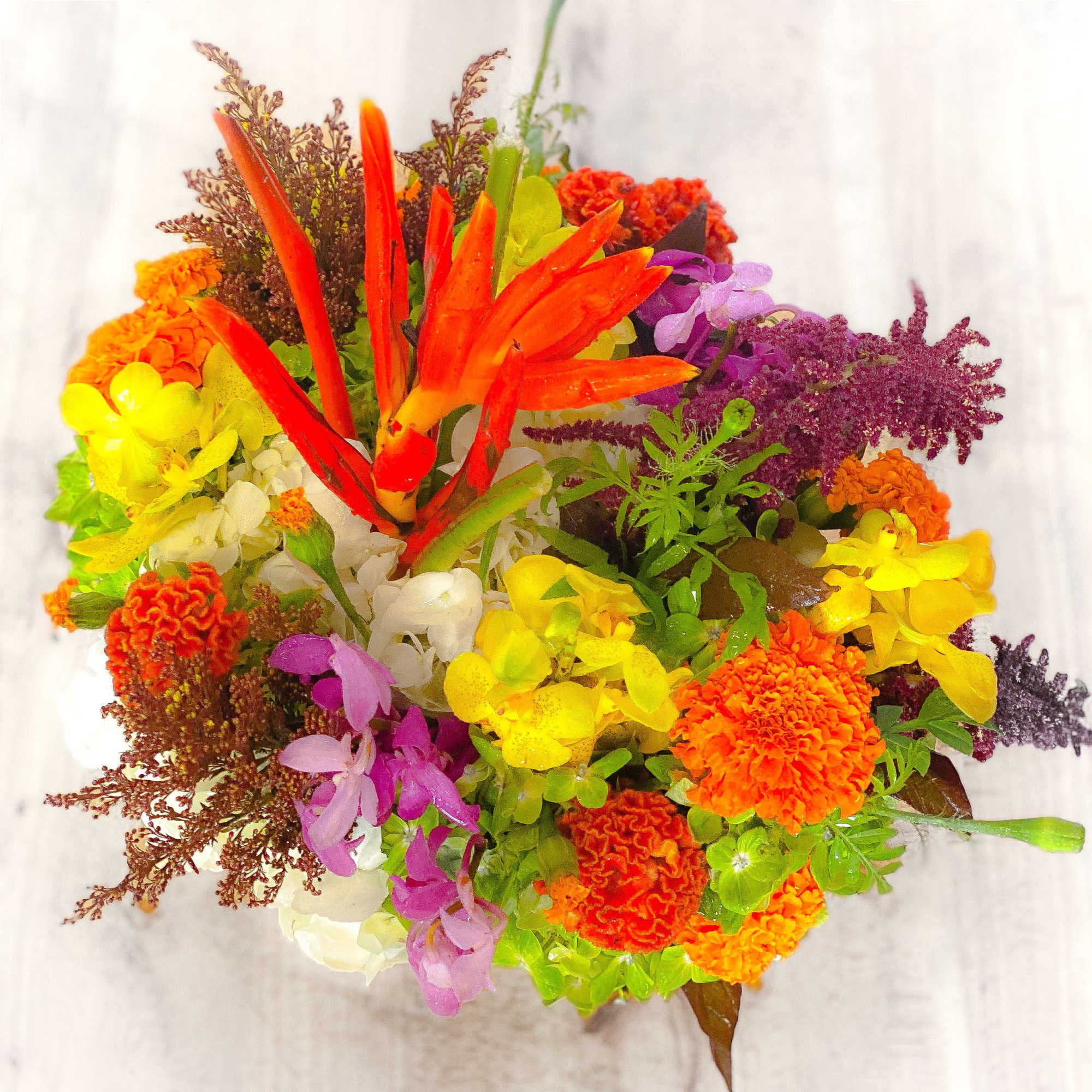 Bright mixed bouquet with orange, yellow, purple, and white flowers