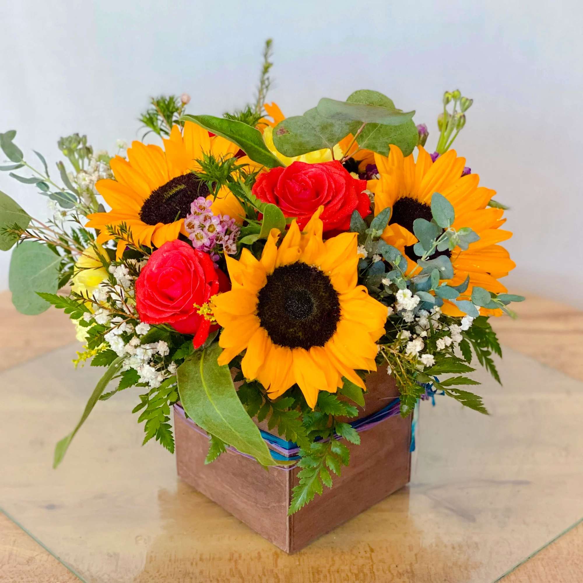 Sunflower and red rose arrangement in a square box