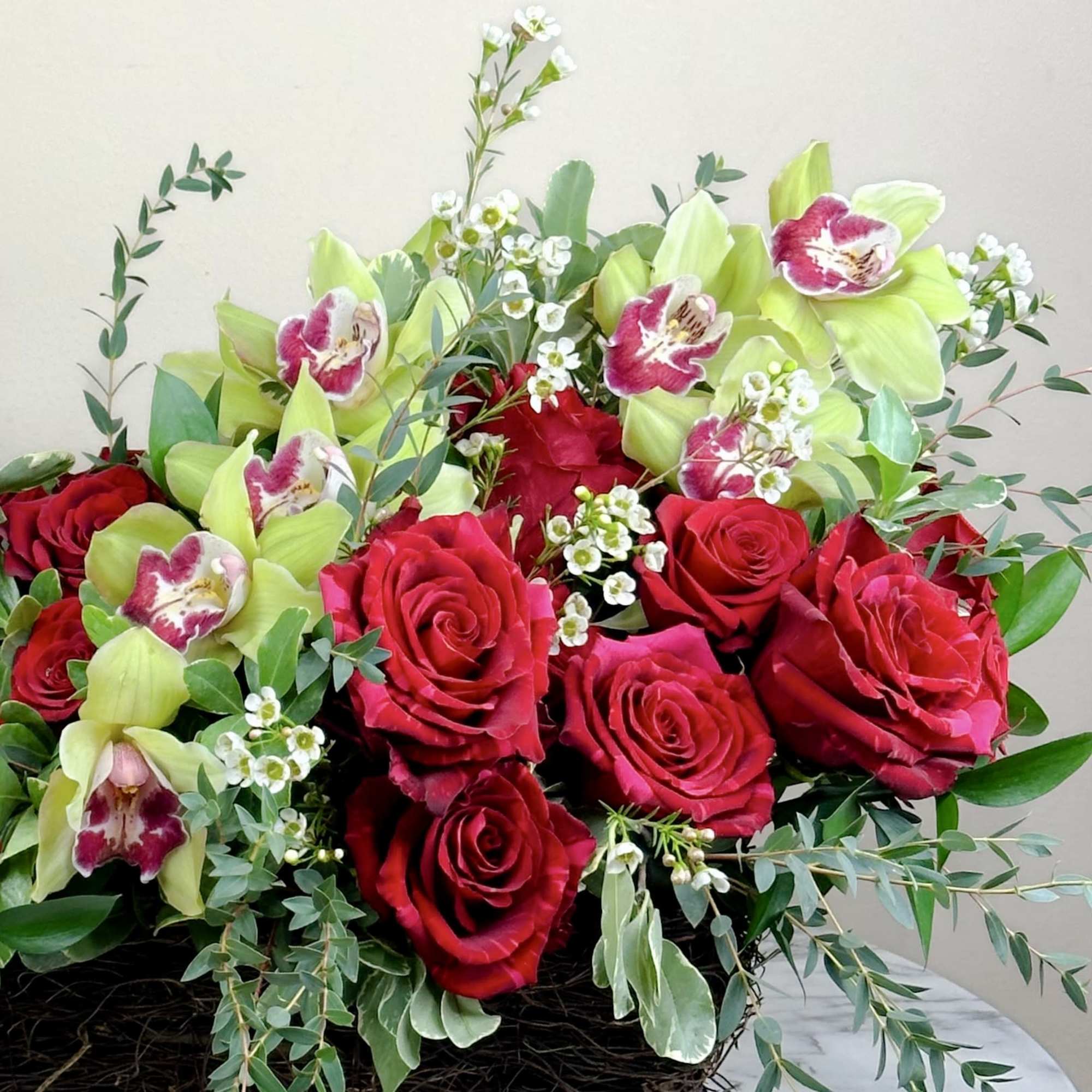 Bouquet of red roses and green orchids with white filler flowers