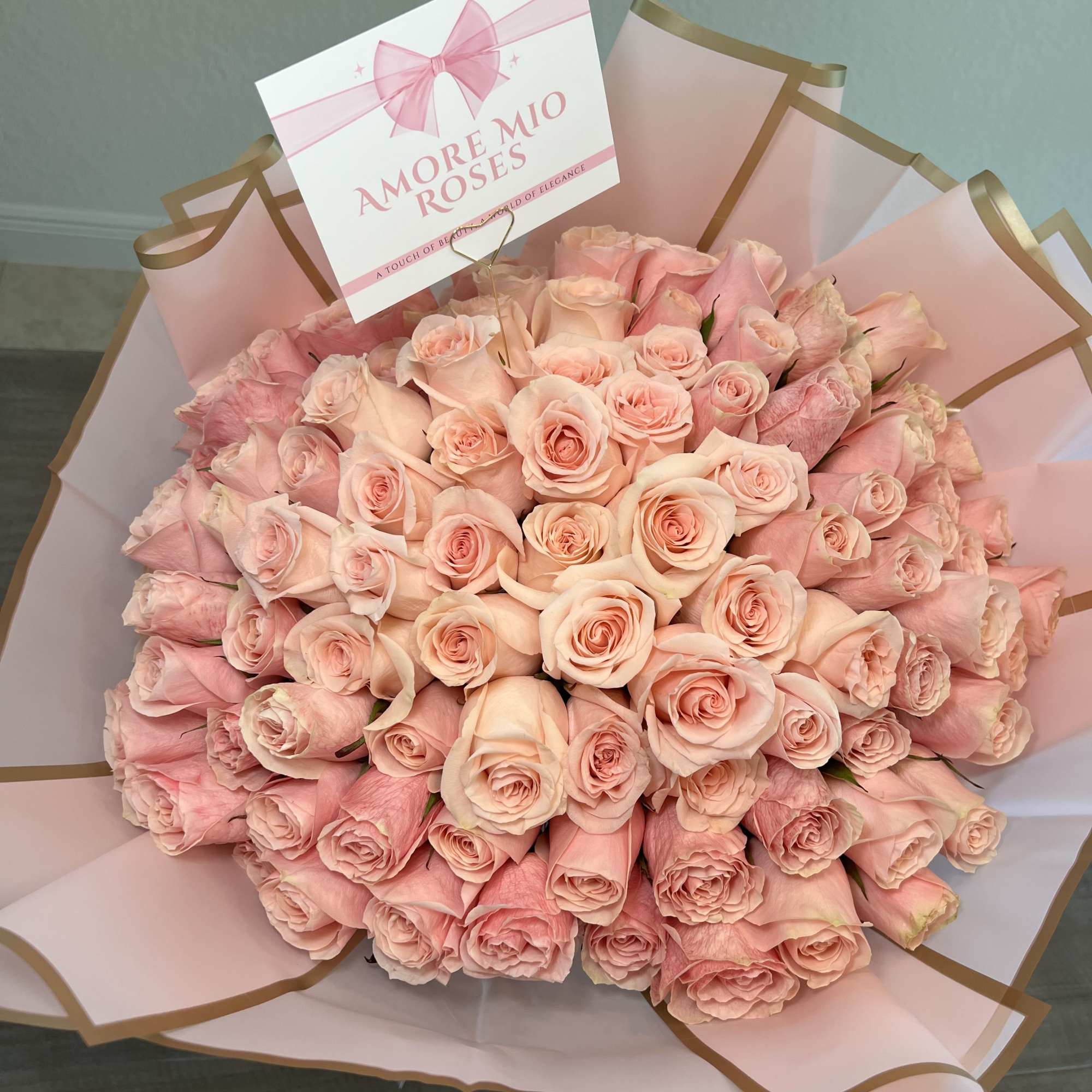 Large bouquet of pale pink roses wrapped in pink paper
