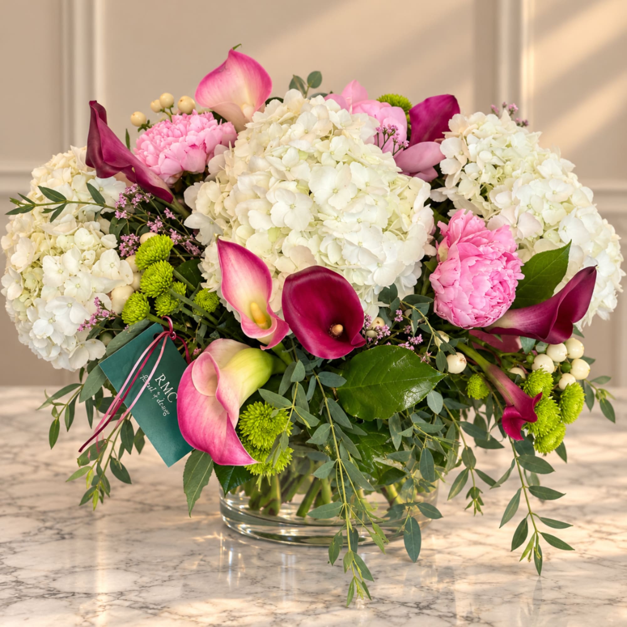 Pink and white floral arrangement with calla lilies and hydrangeas in a glass vase, photo 2 of 2