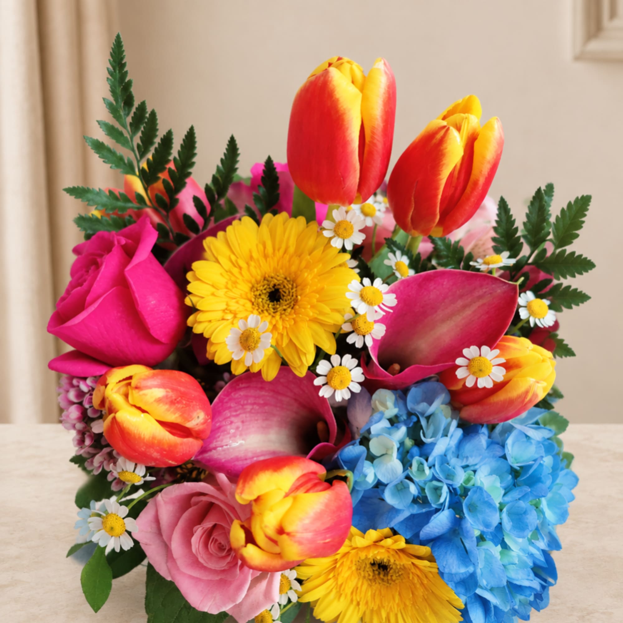 Bright mixed bouquet with tulips, roses, daisies, and blue hydrangea