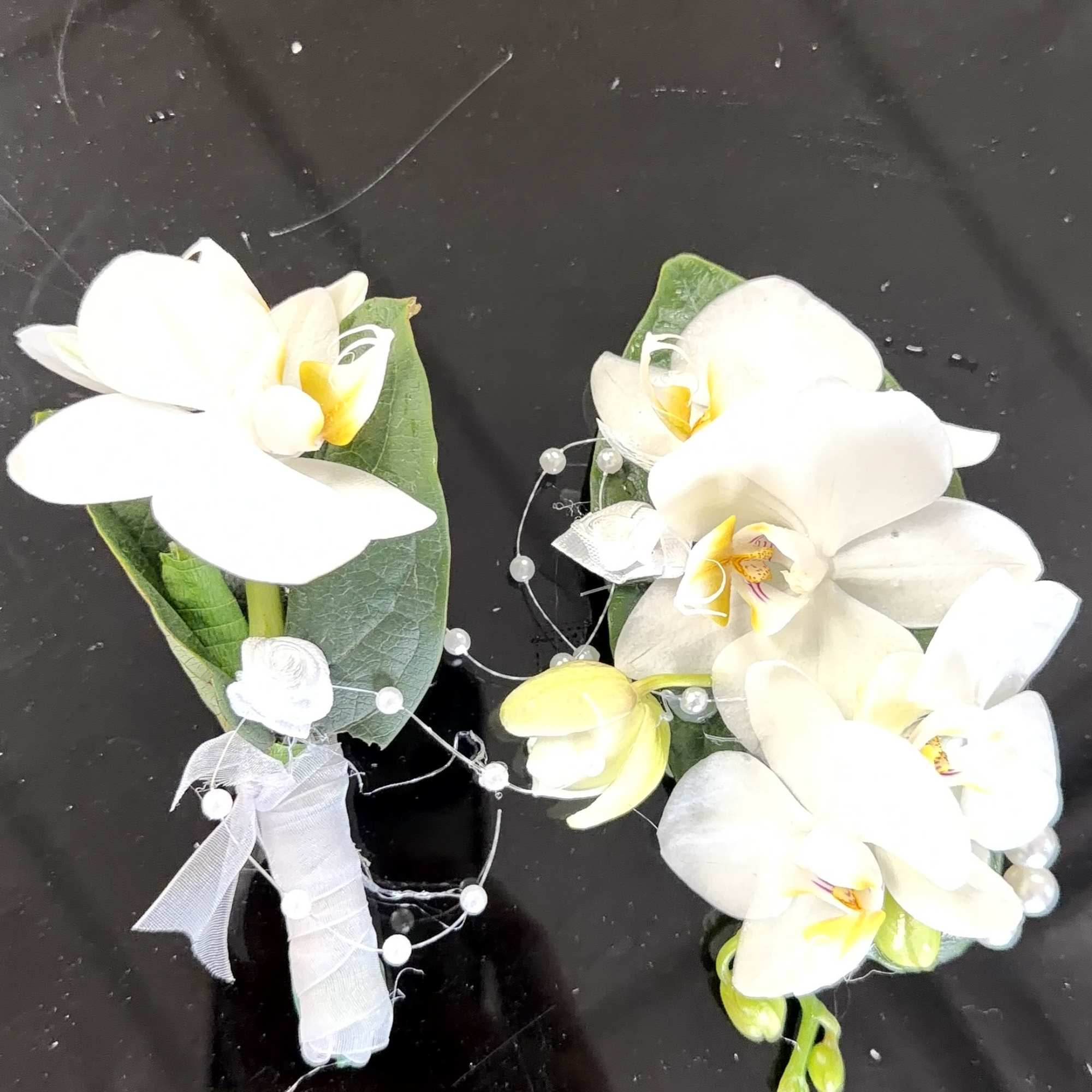 Cascading white Phalaenopsis orchids with pale yellow centers create a quietly striking, photo 2 of 2