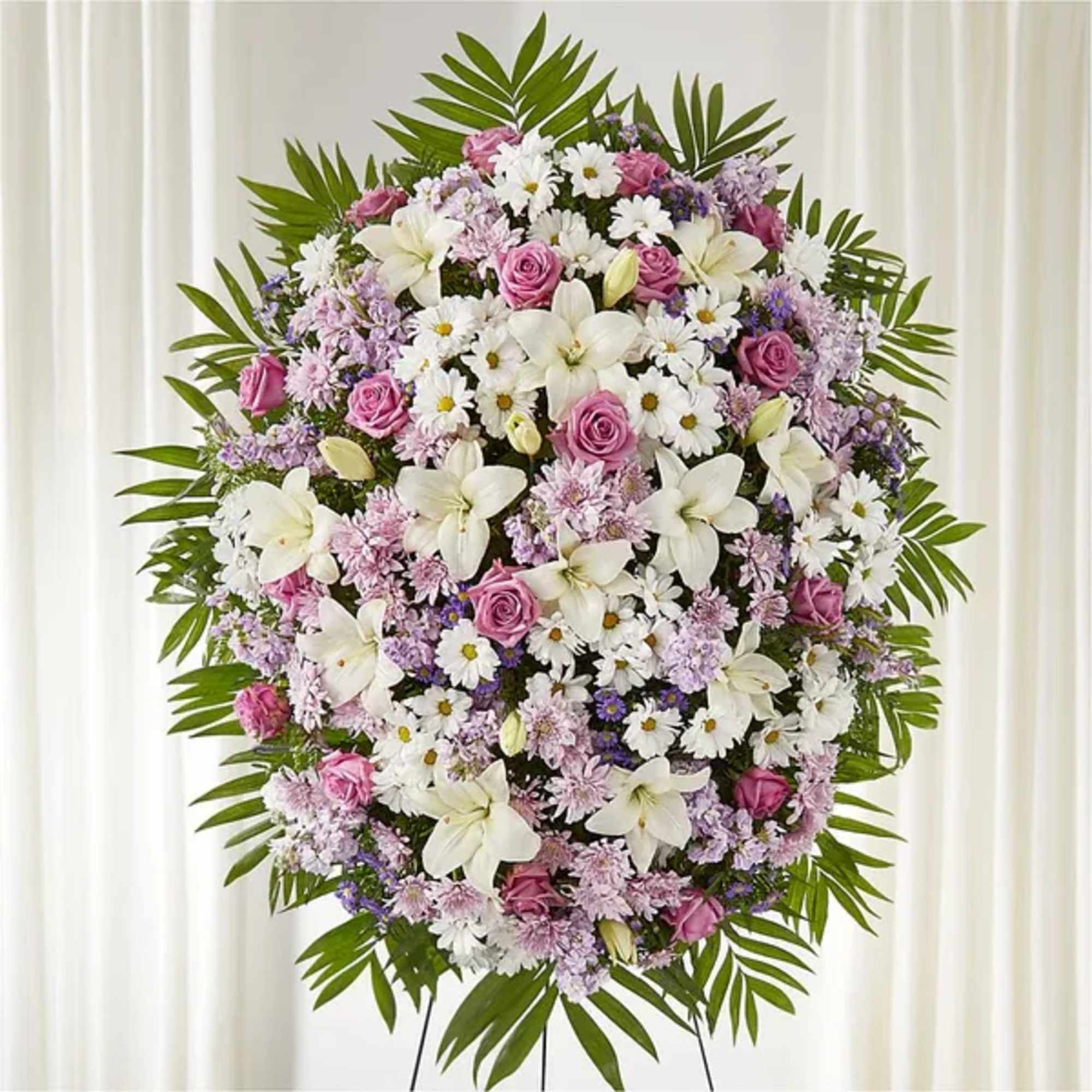 Standing floral wreath with pink and white flowers on a green leaf frame