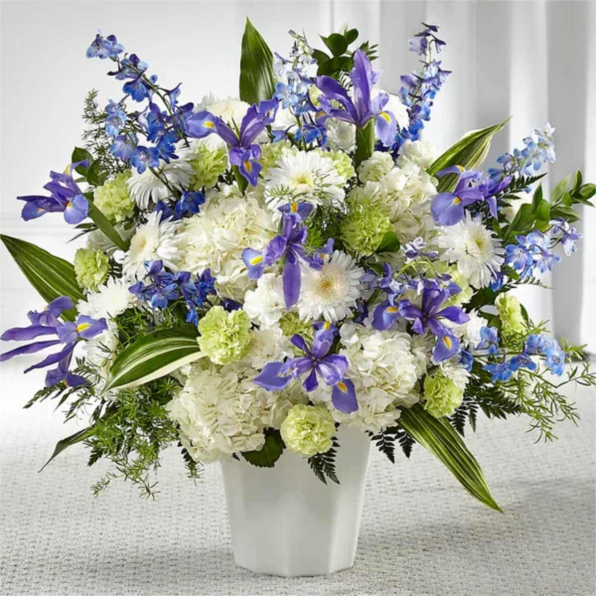 White and purple floral arrangement in a white vase