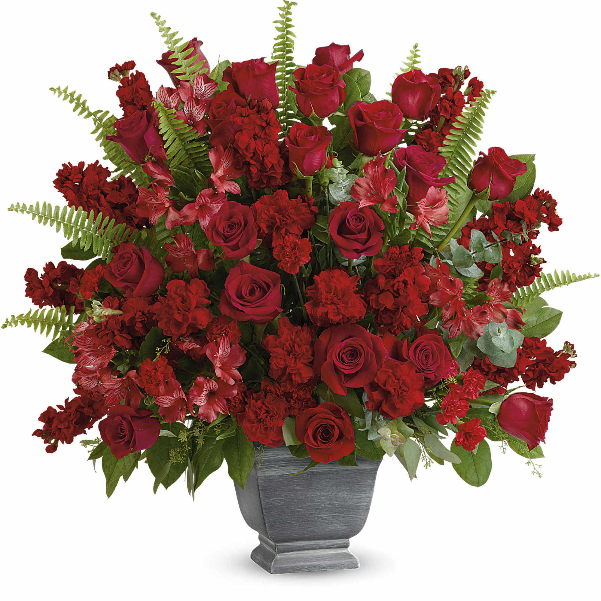 Red roses and carnations arranged in a gray urn vase