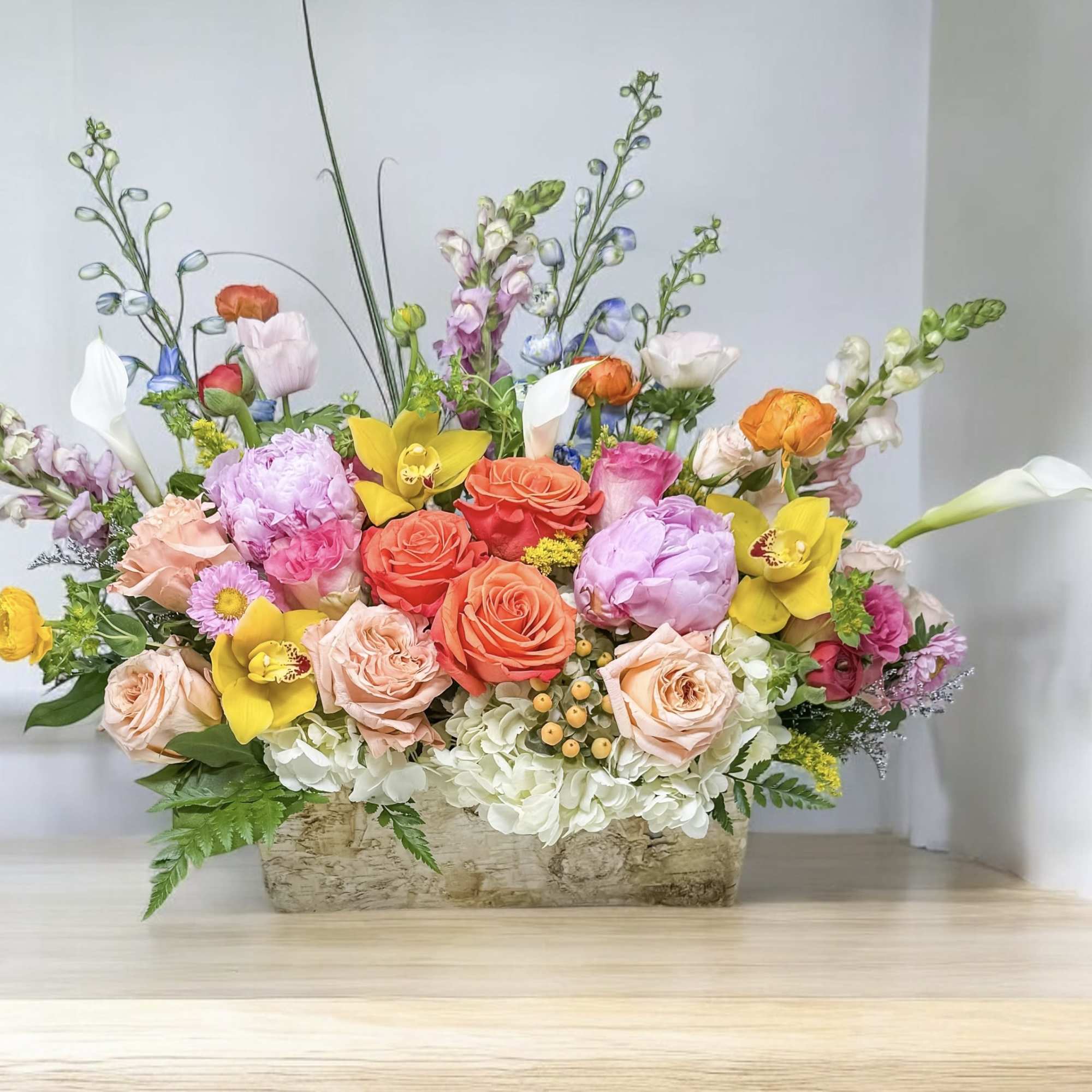 Colorful mixed flower arrangement in a rectangular container