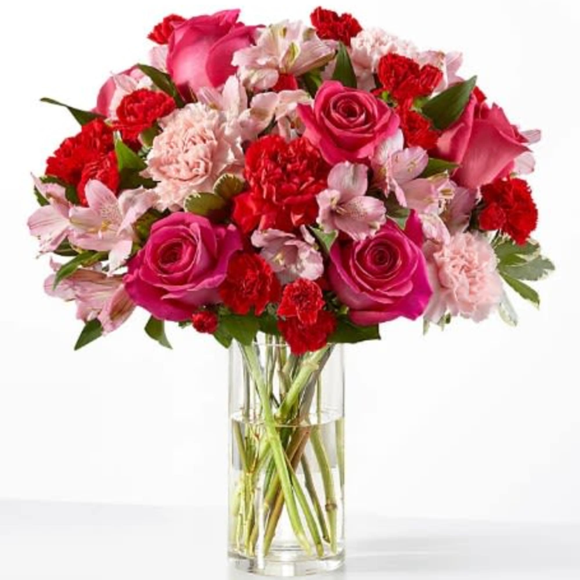 Pink roses, red and pink carnations, and alstroemeria arranged in a clear glass cylinder vase