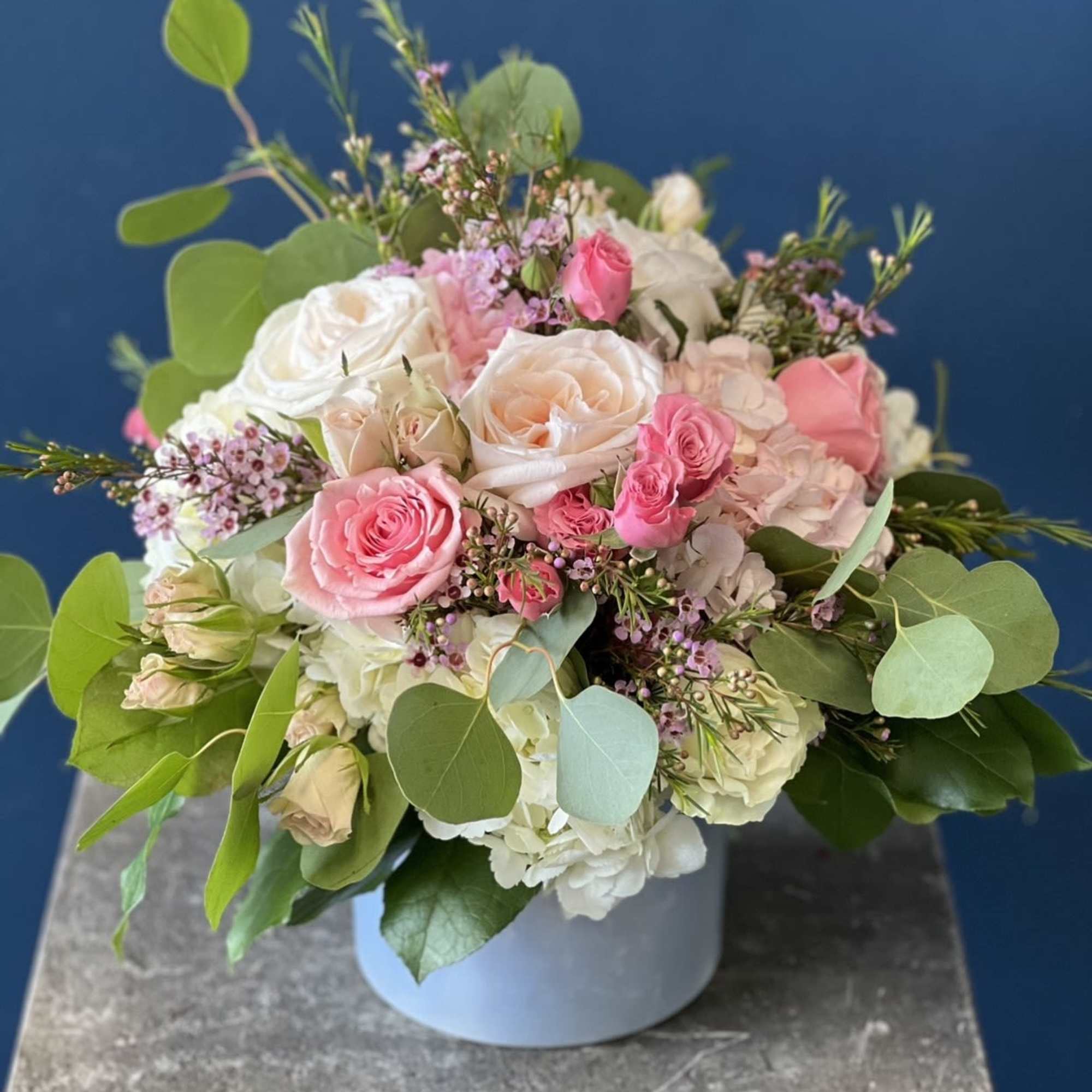 Pink and white rose bouquet in a light blue hat box