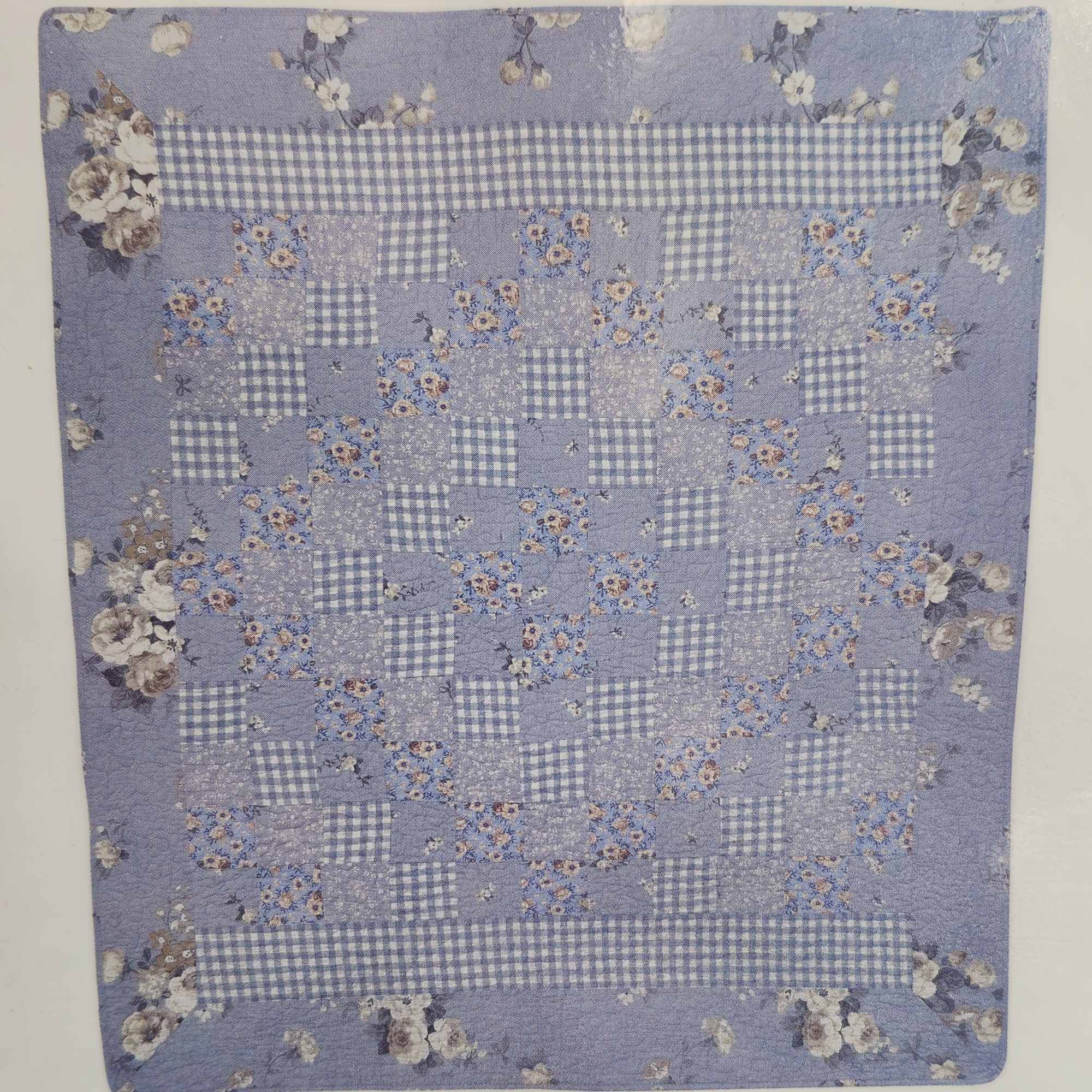 The soft, patchwork quilt in soothing blue, white and lavender tones offers