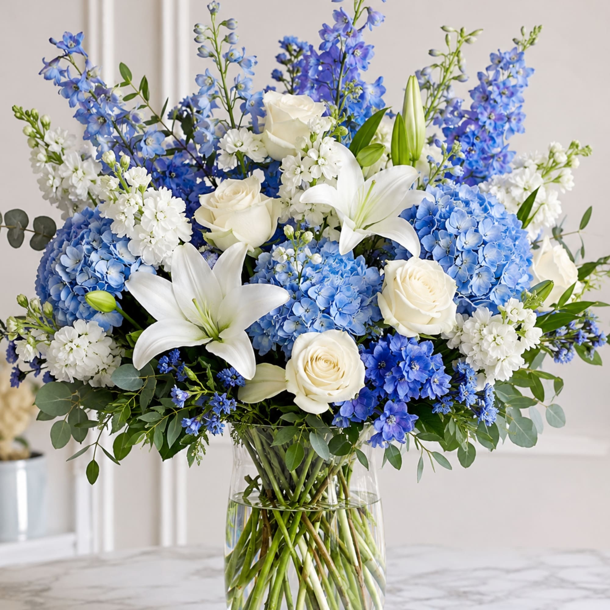 A cool-toned bouquet of blue hydrangeas and white lilies that feels like
