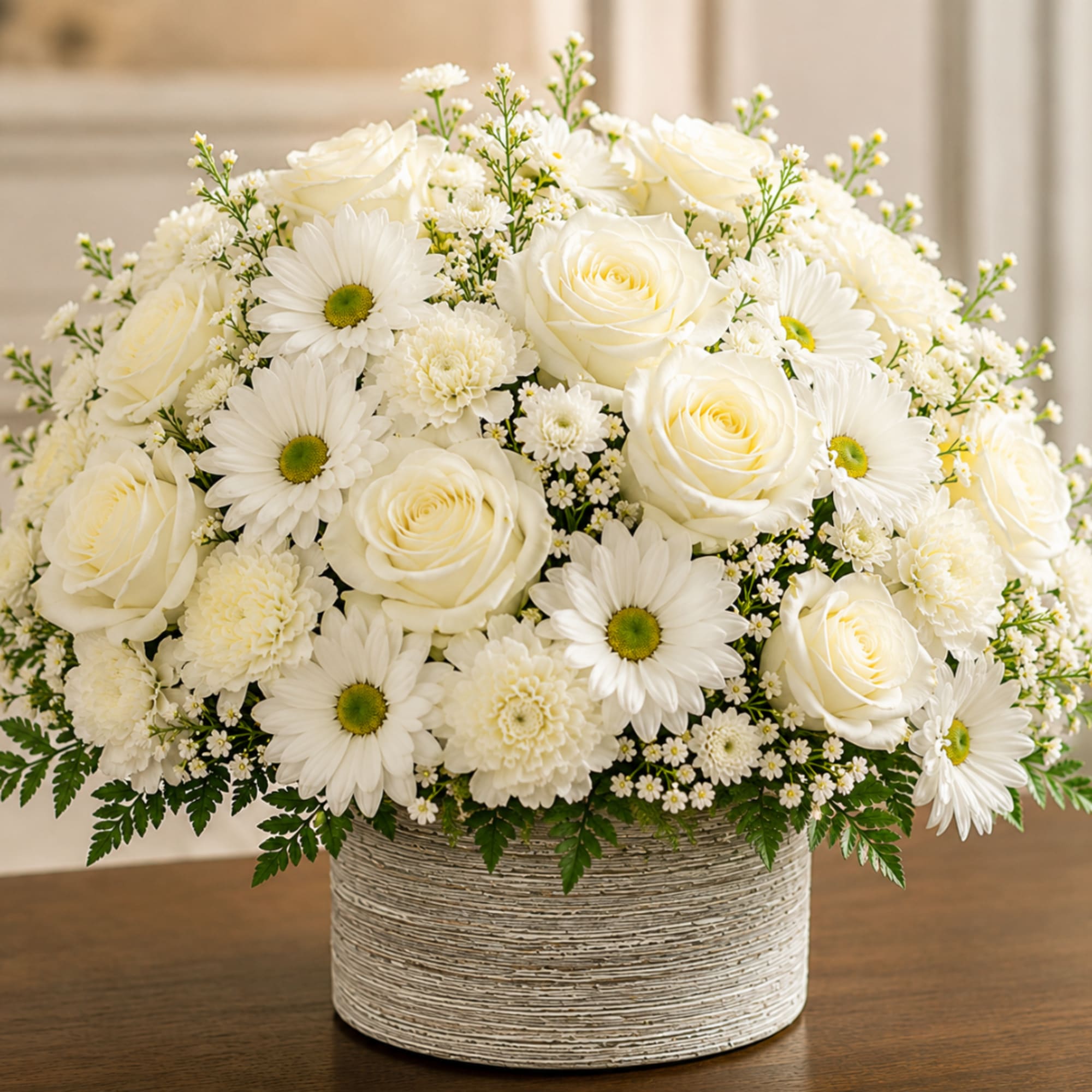 White roses and daisies arranged in a textured round vase