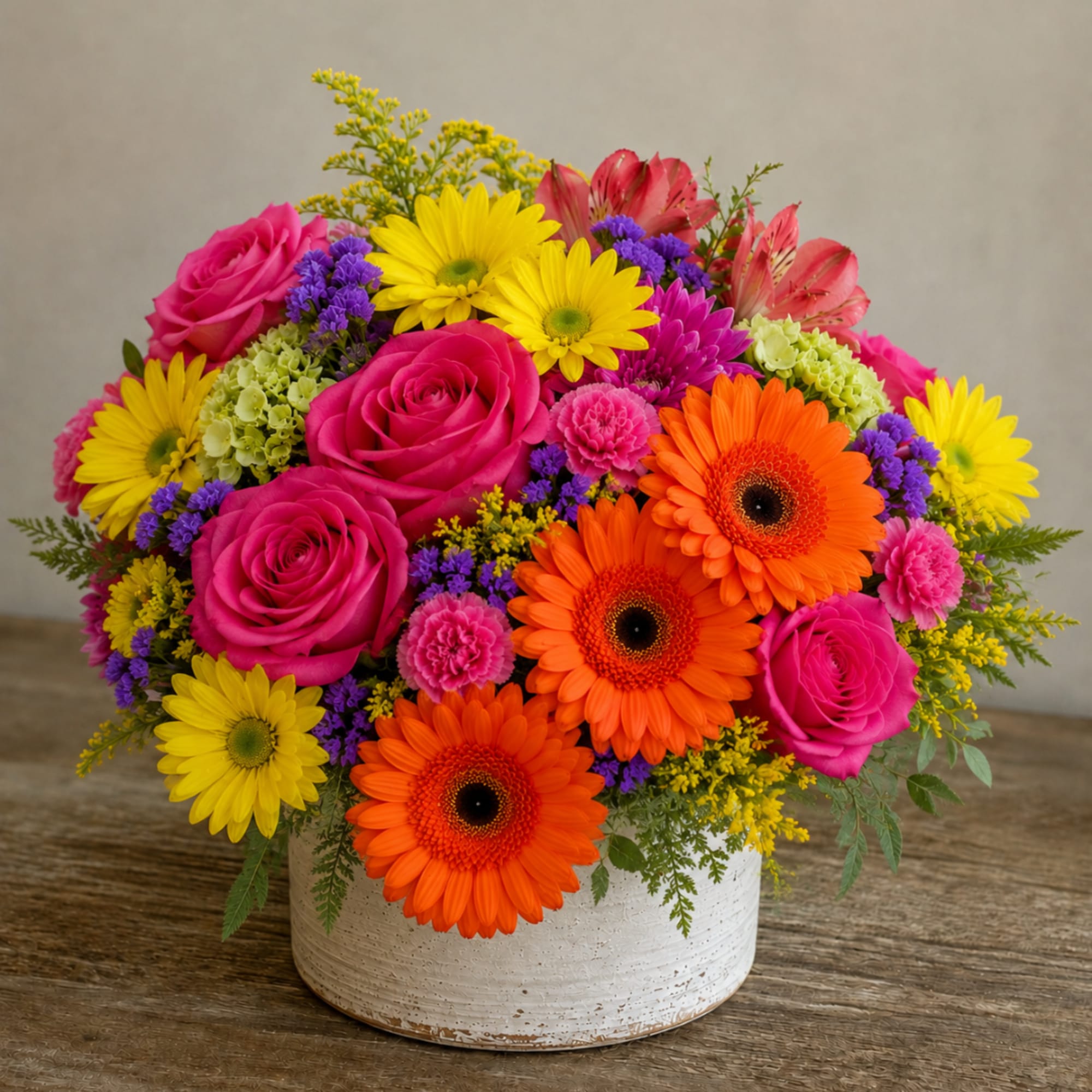 Bright mixed bouquet in a white ceramic vase with pink roses and orange gerbera daisies