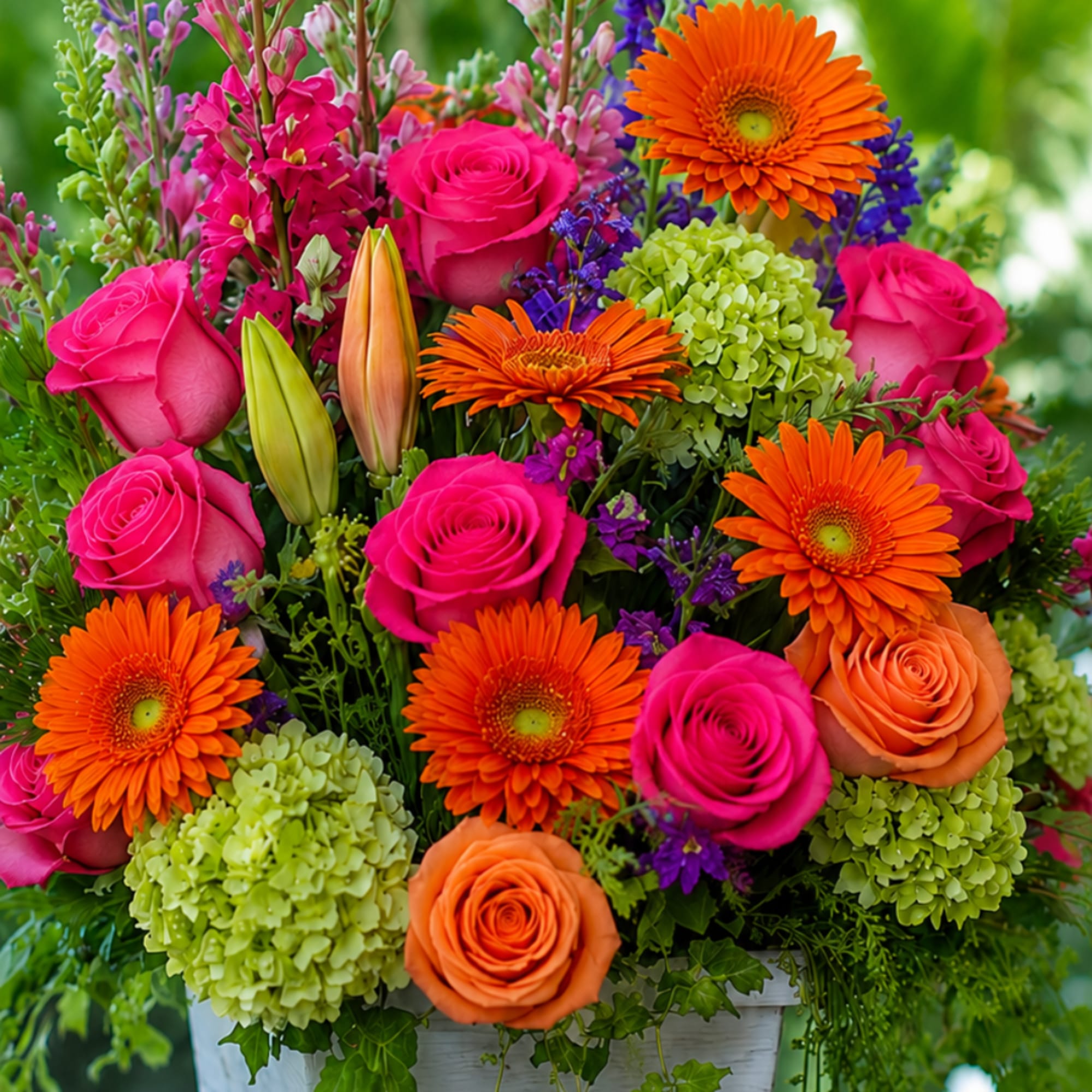Bright mixed bouquet with pink and orange roses, gerbera daisies, and green hydrangeas