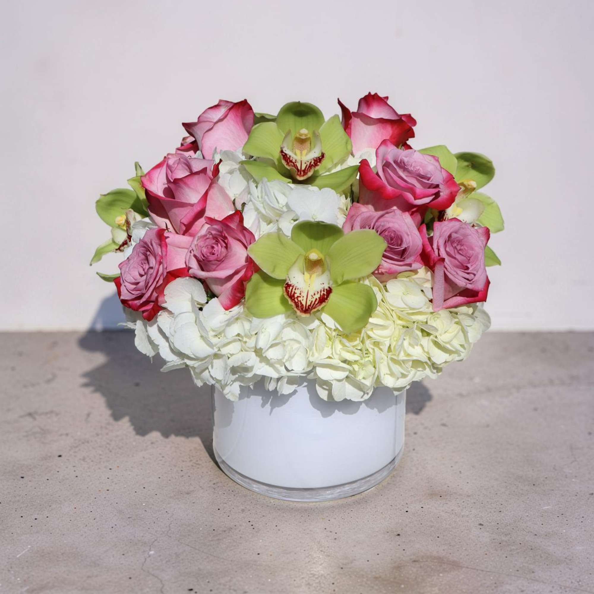 Soft white hydrangeas form a lush, dome-shaped base crowned with clusters of