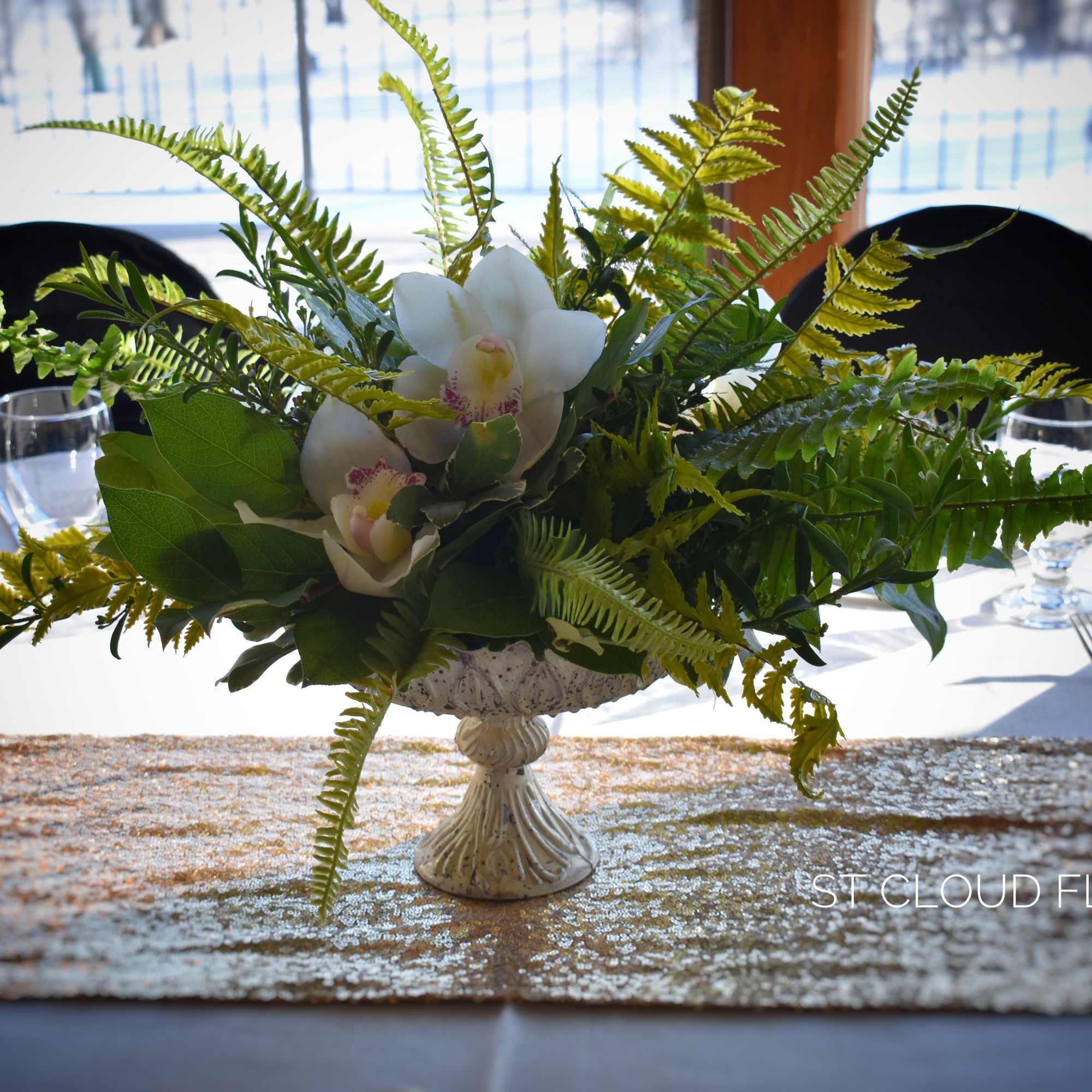 White orchid centerpiece in a low decorative vase