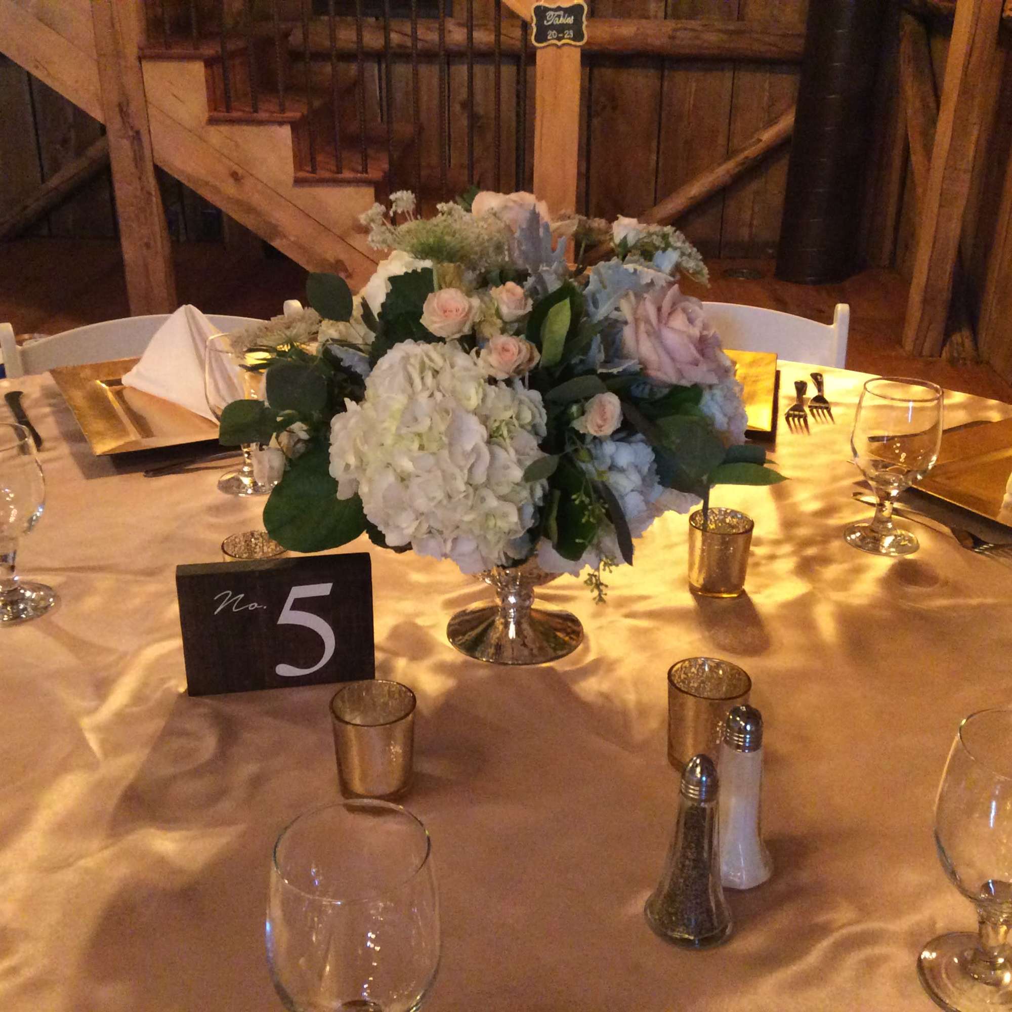 Floral centerpiece in a silver vase on a set dining table