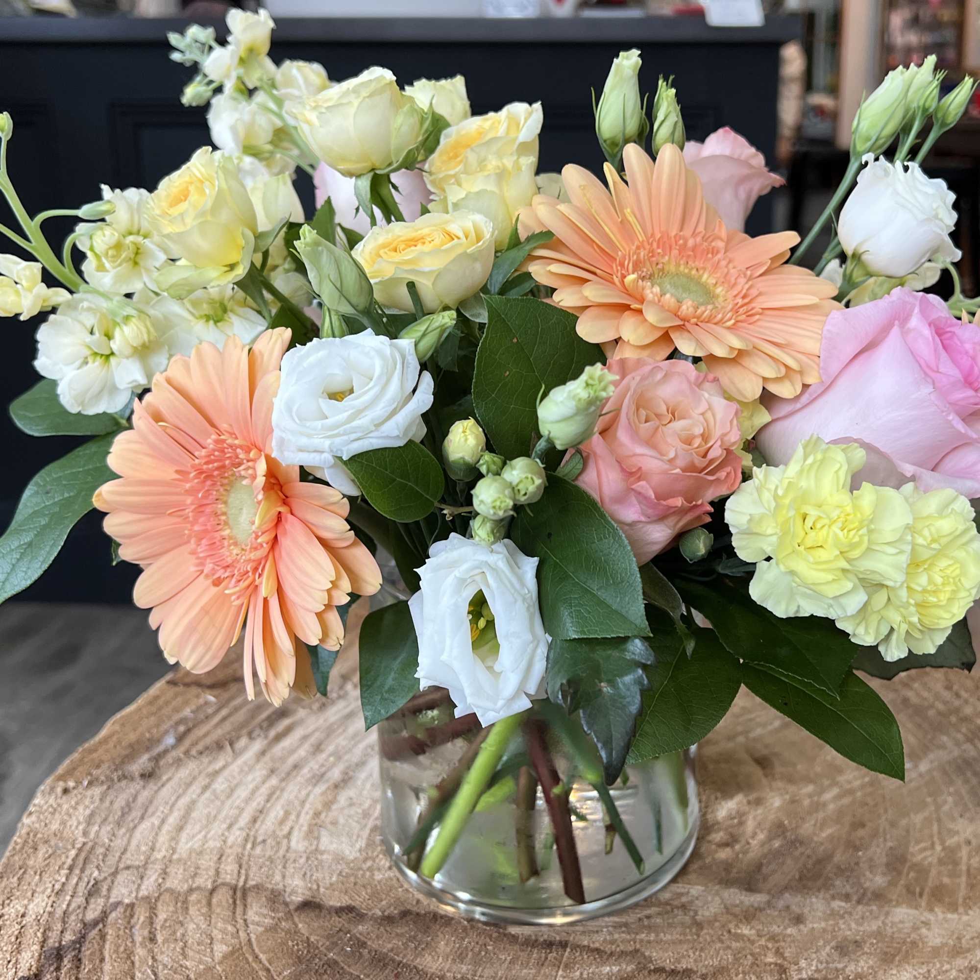 This arrangement includes peach and pink  roses, gerbera daisies, stock, and, photo 2 of 2