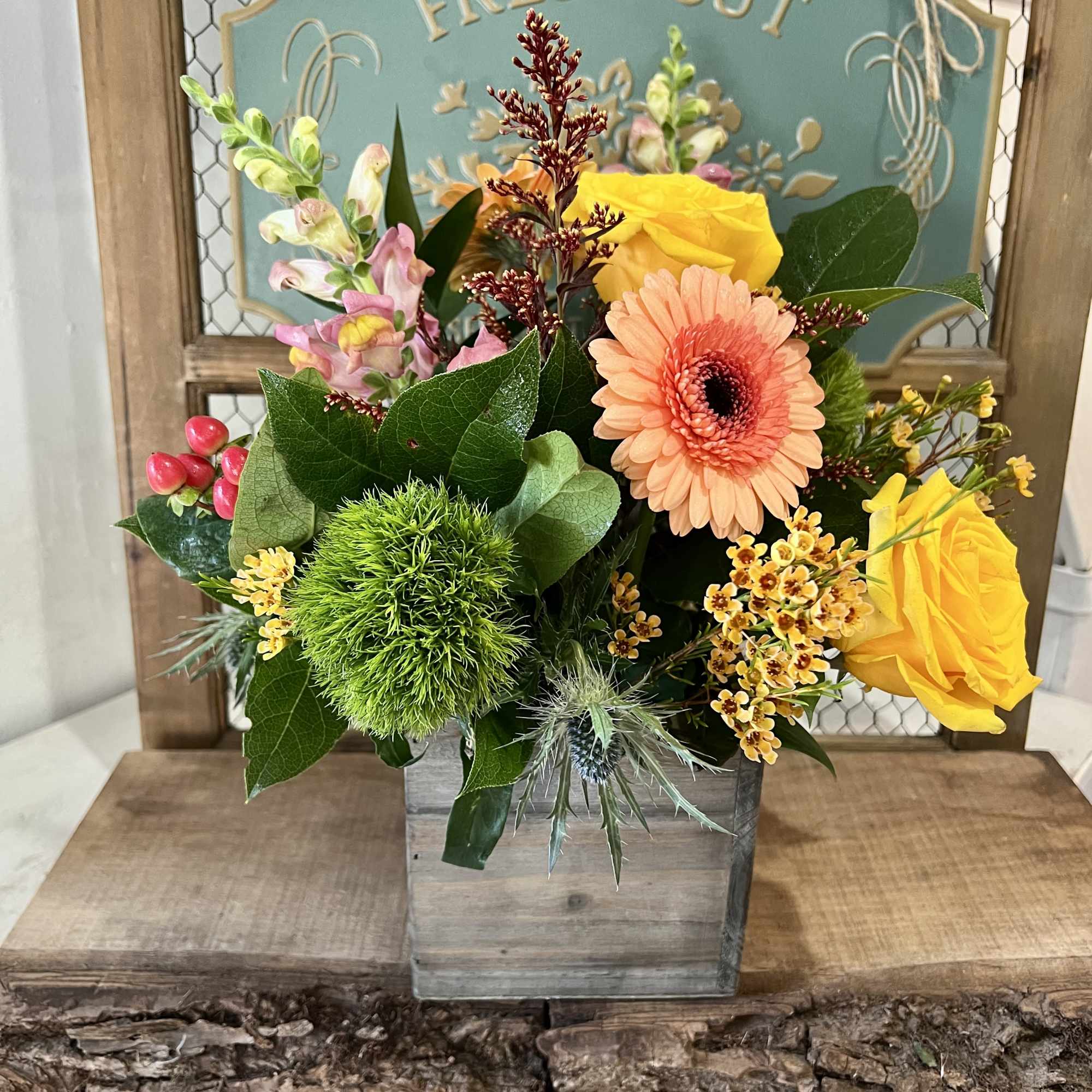Mixed bouquet in a wooden box with yellow roses and a peach gerbera daisy