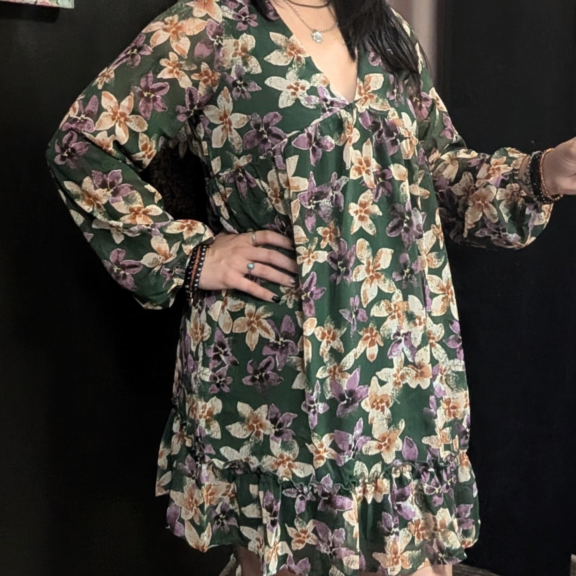 Woman wearing a green floral dress against a black background