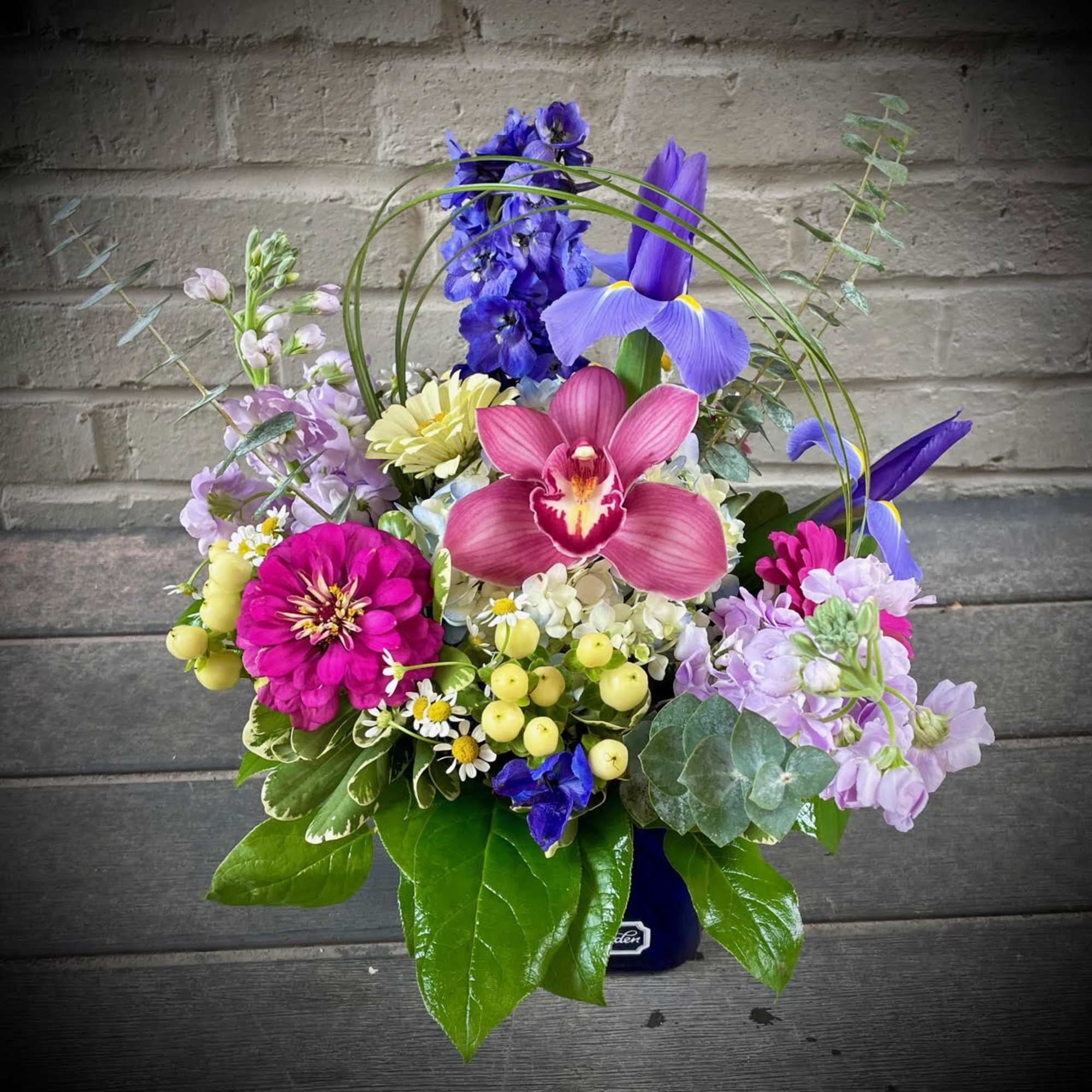 Colorful mixed flower arrangement in a dark vase