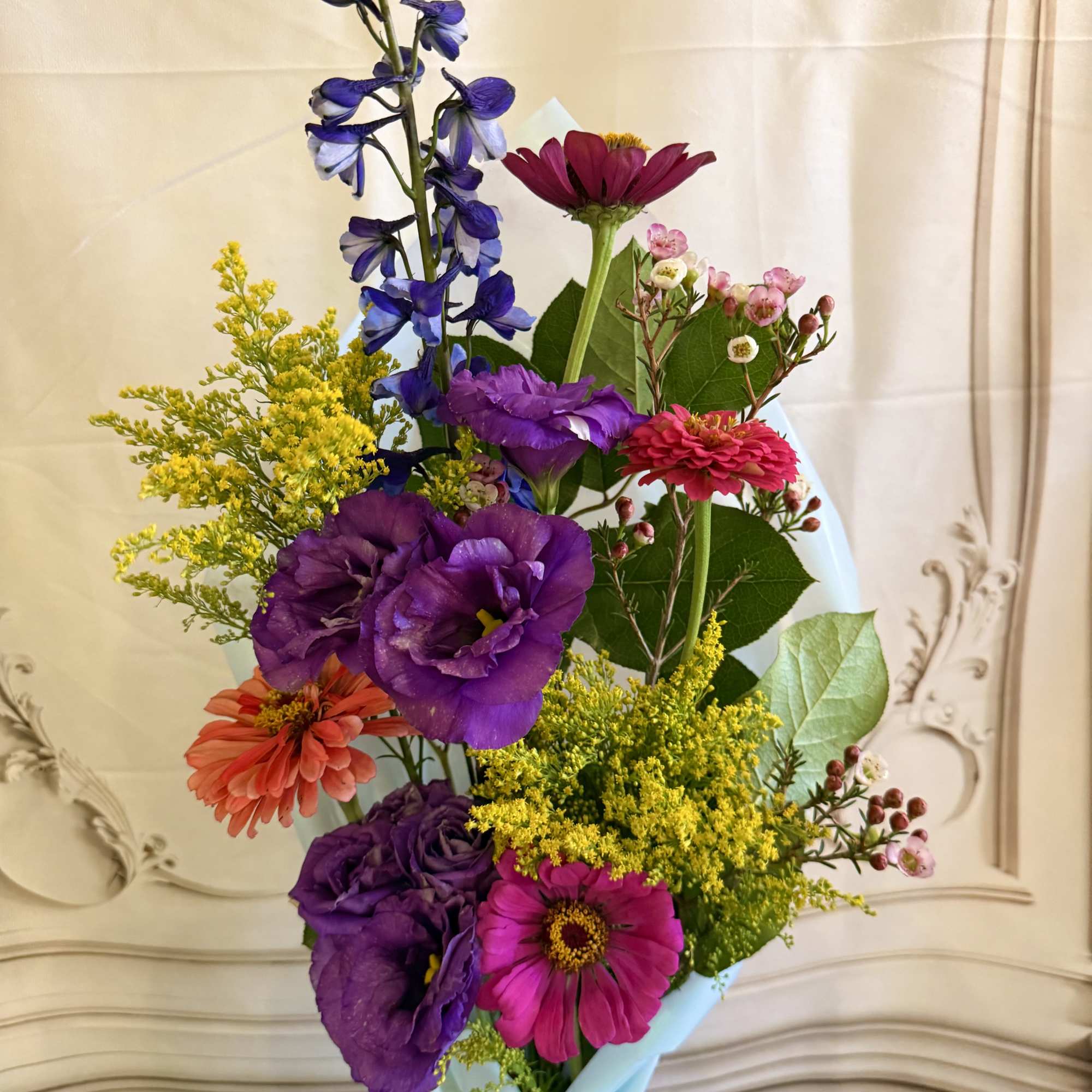 This beautiful wrapped bouquet Is filled with vibrant flowers grown in our