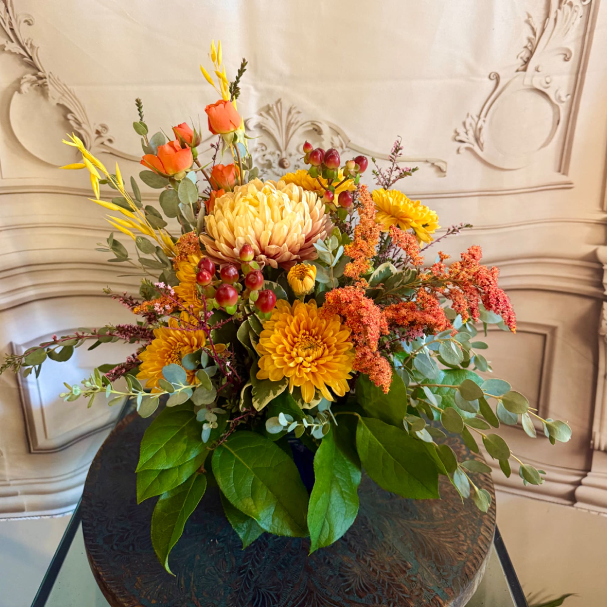Mixed bouquet of yellow and orange flowers in a low container