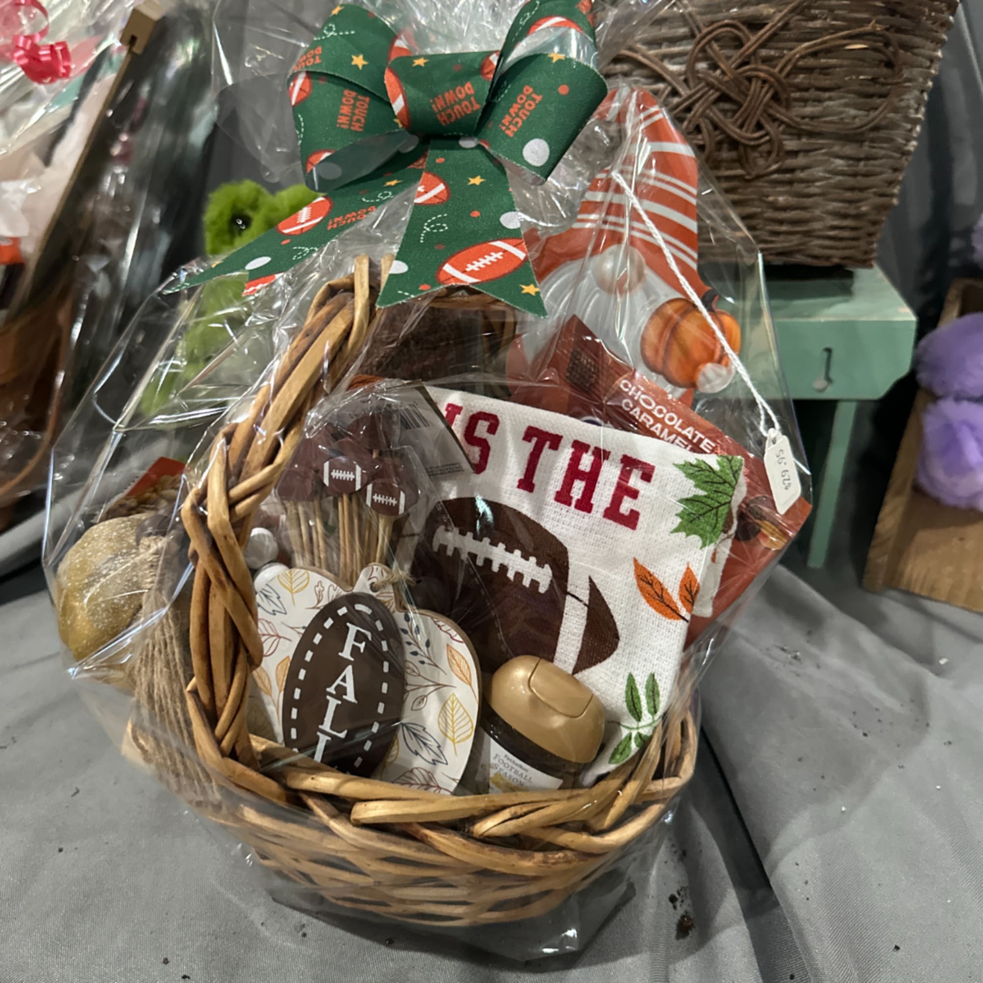 Football-themed gift basket in a wicker basket wrapped in cellophane