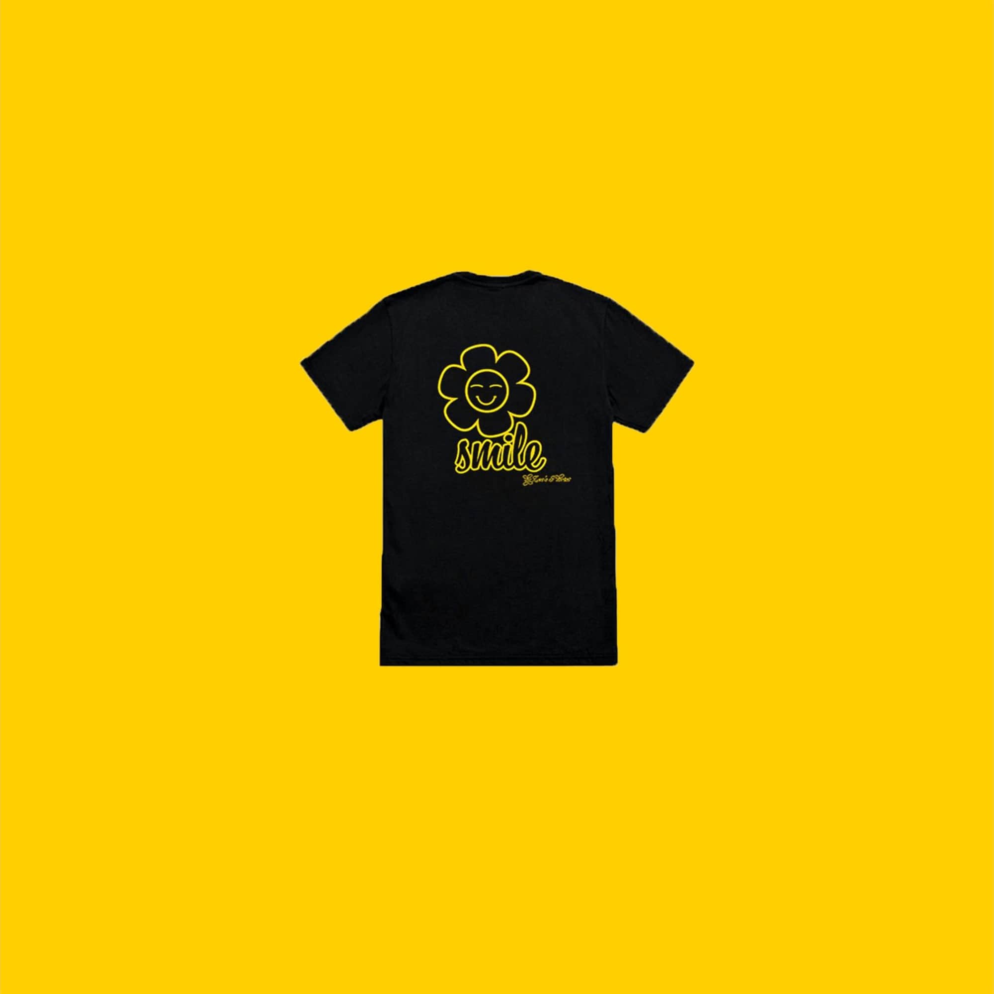 Black T-shirt with a yellow smiley flower graphic on a yellow background