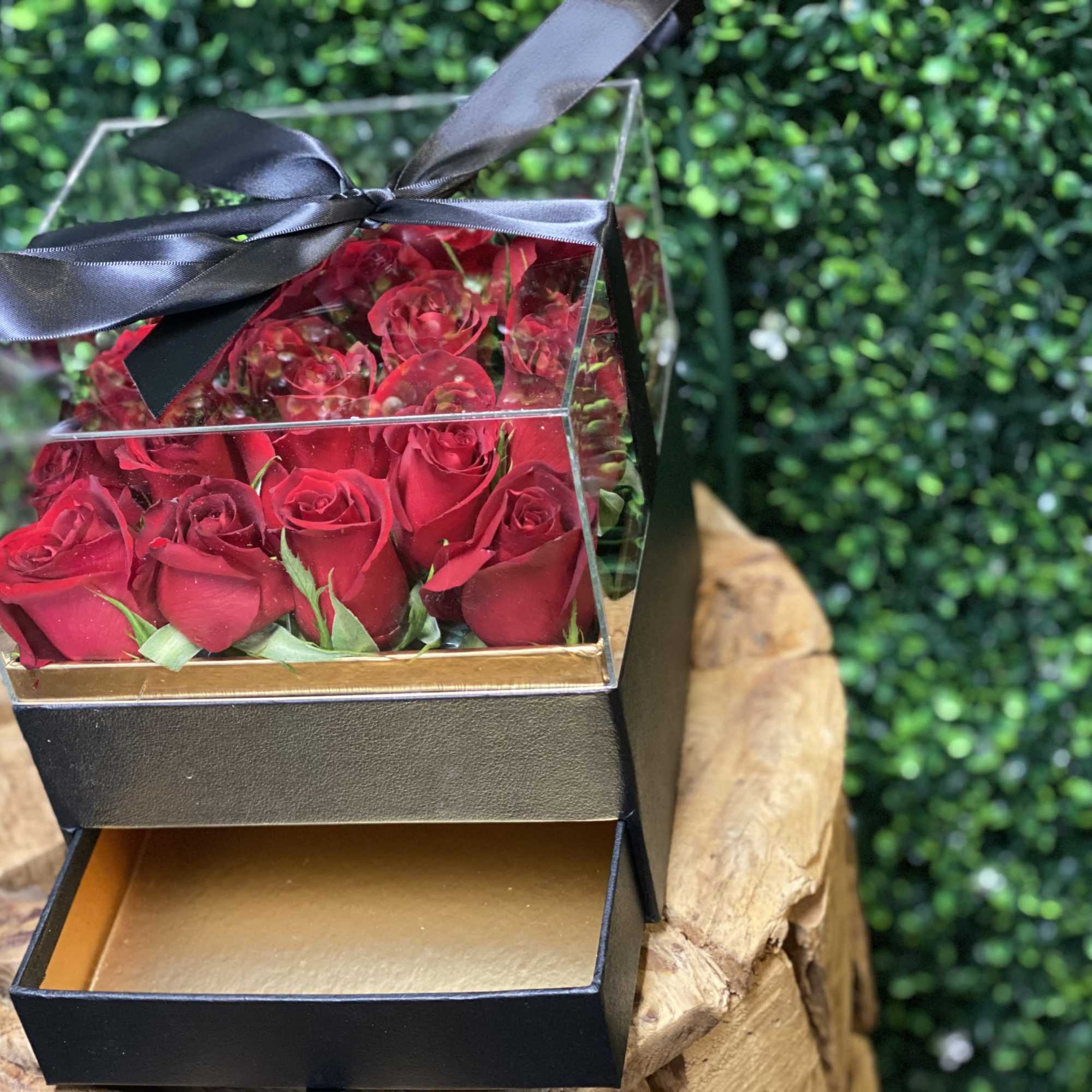 Box of red roses with a black ribbon bow