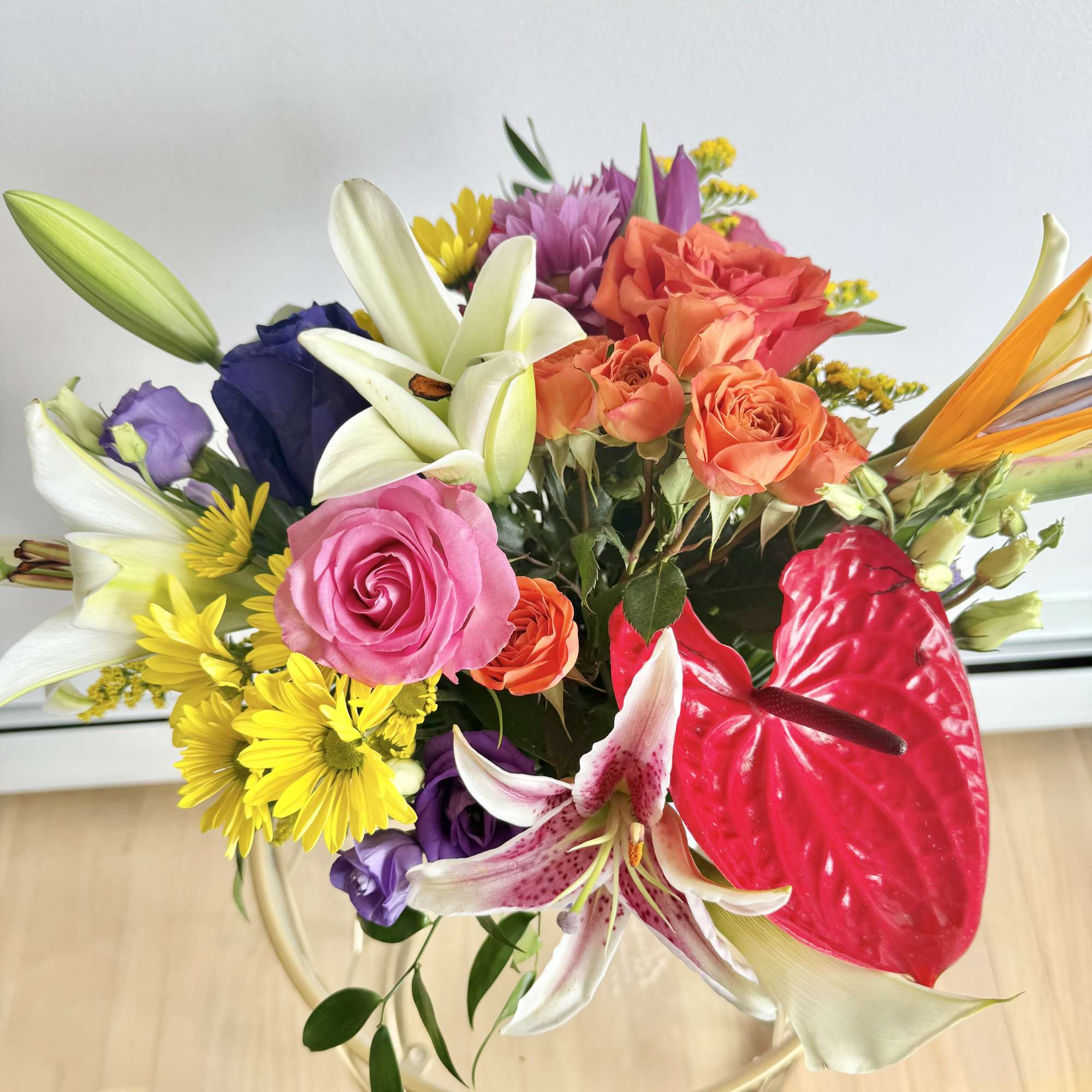 Mixed bouquet with roses, lilies, an anthurium, and daisies