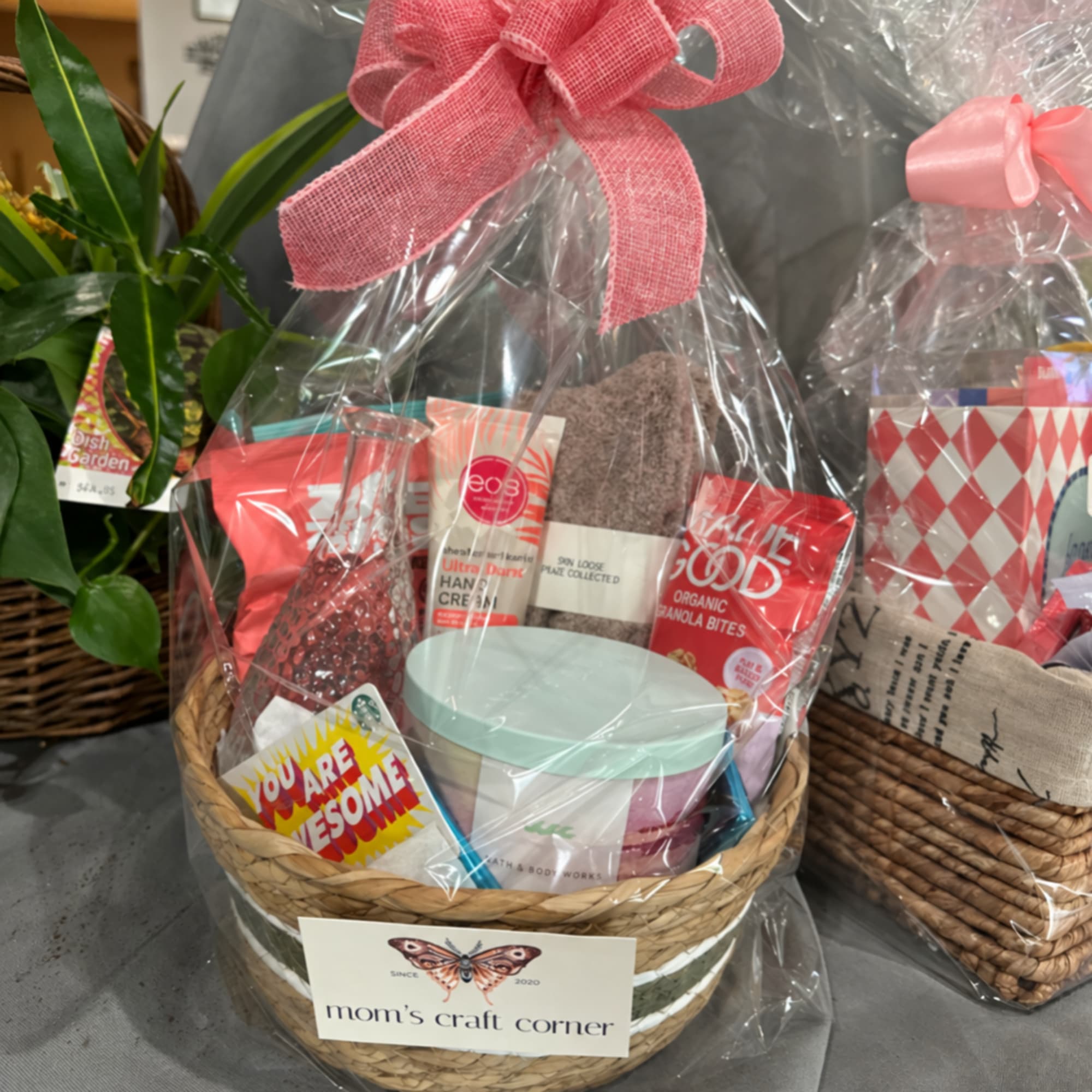 Gift basket with snacks, a candle, and a card wrapped in clear plastic