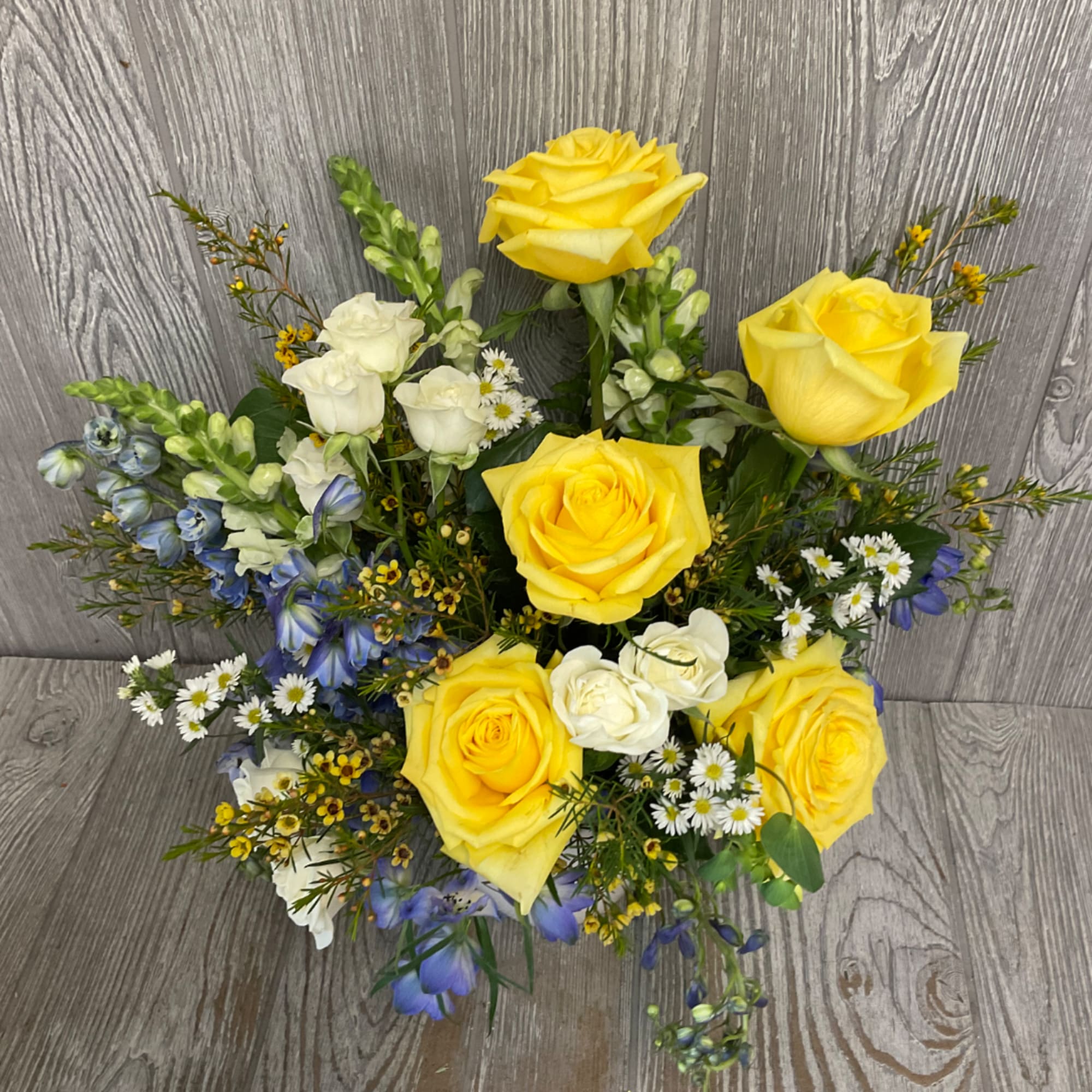Bouquet of yellow and white roses with blue flowers