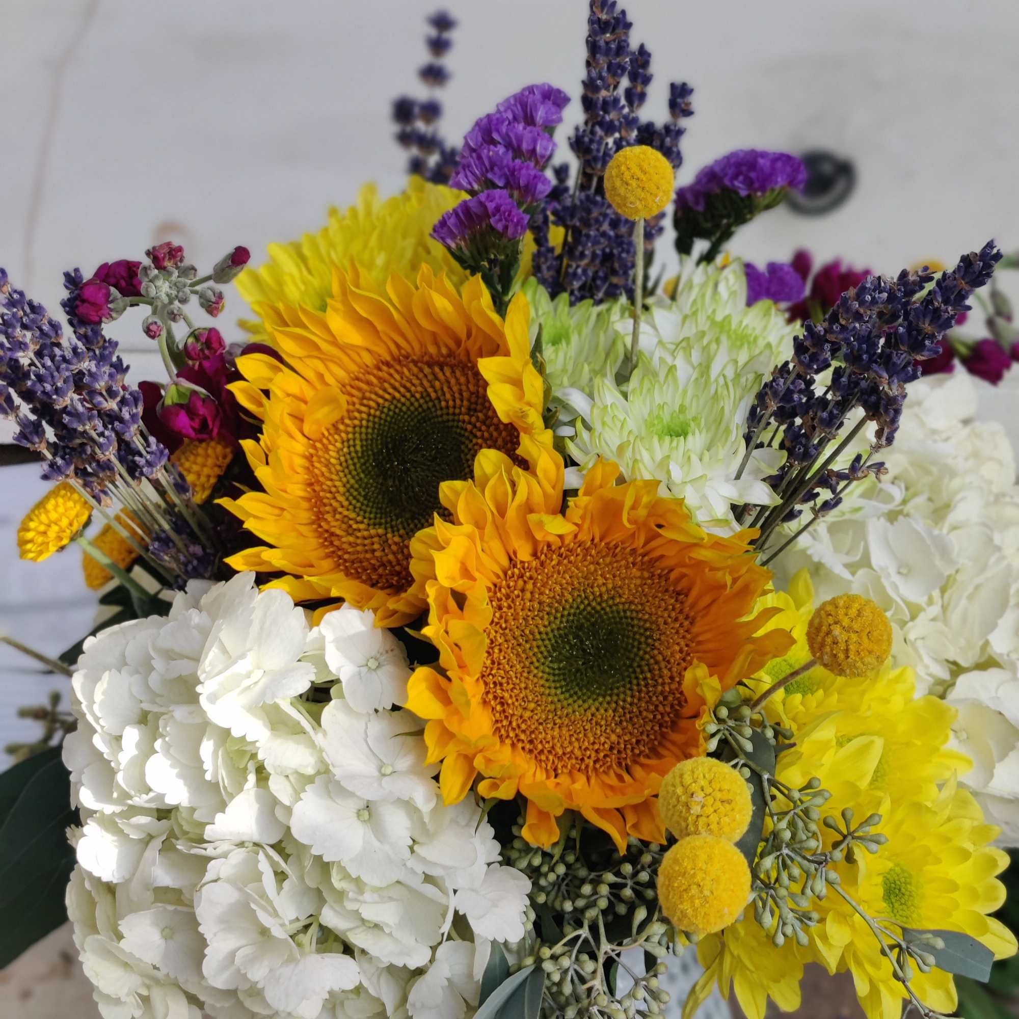 Bouquet with sunflowers, white hydrangeas, and purple lavender-like blooms
