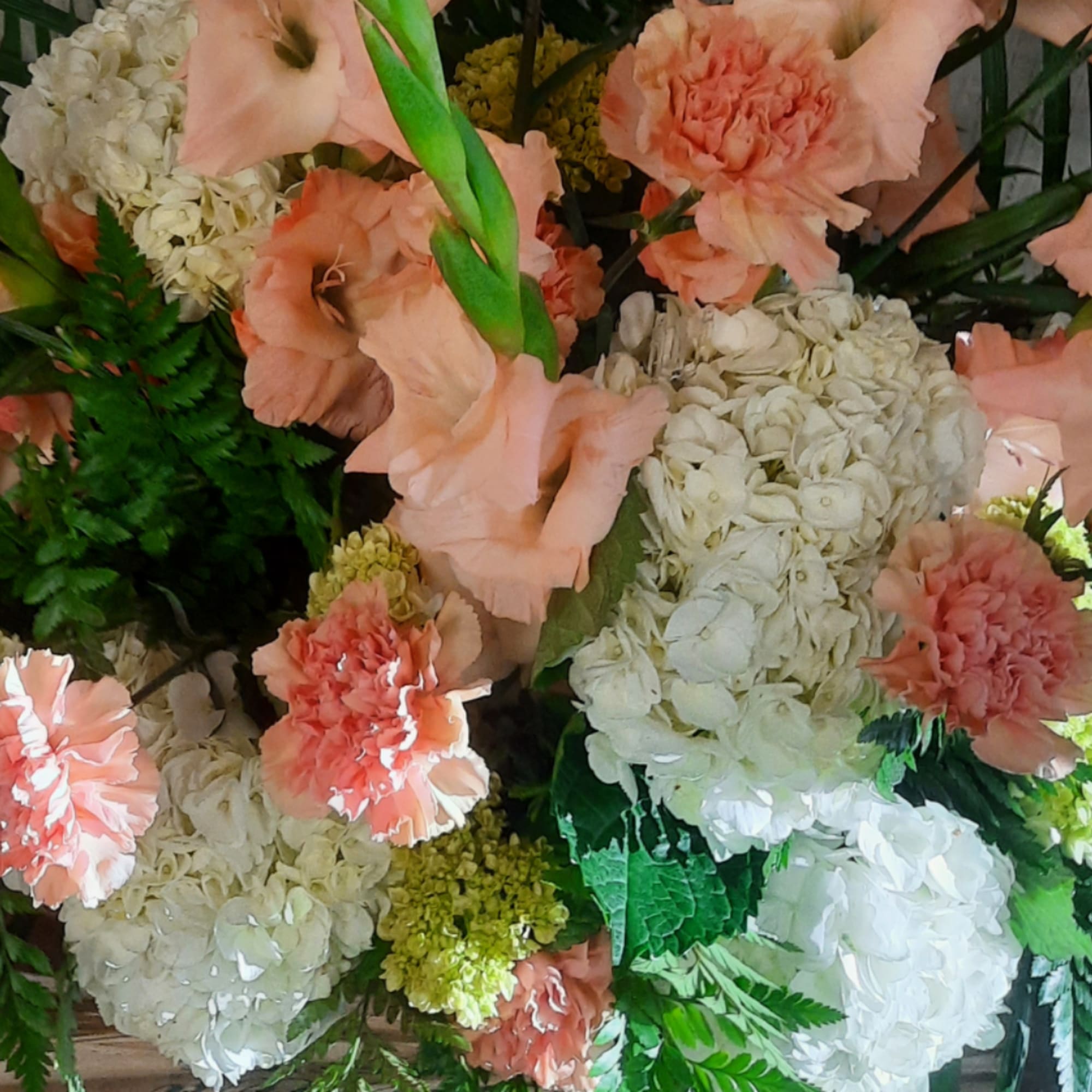 Peach gladiolus and carnations with white hydrangeas in a mixed bouquet