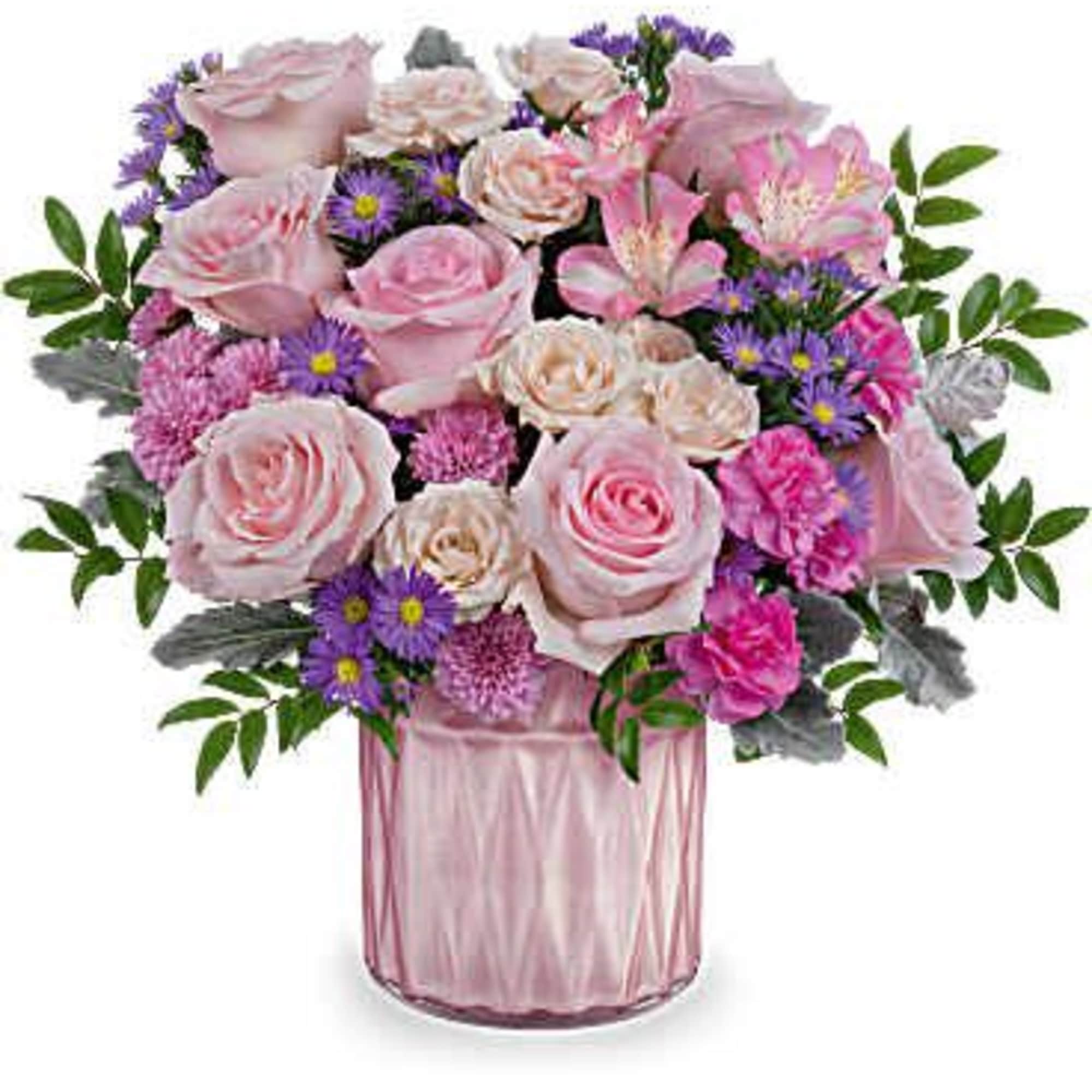 Pink roses and purple flowers arranged in a pink glass vase