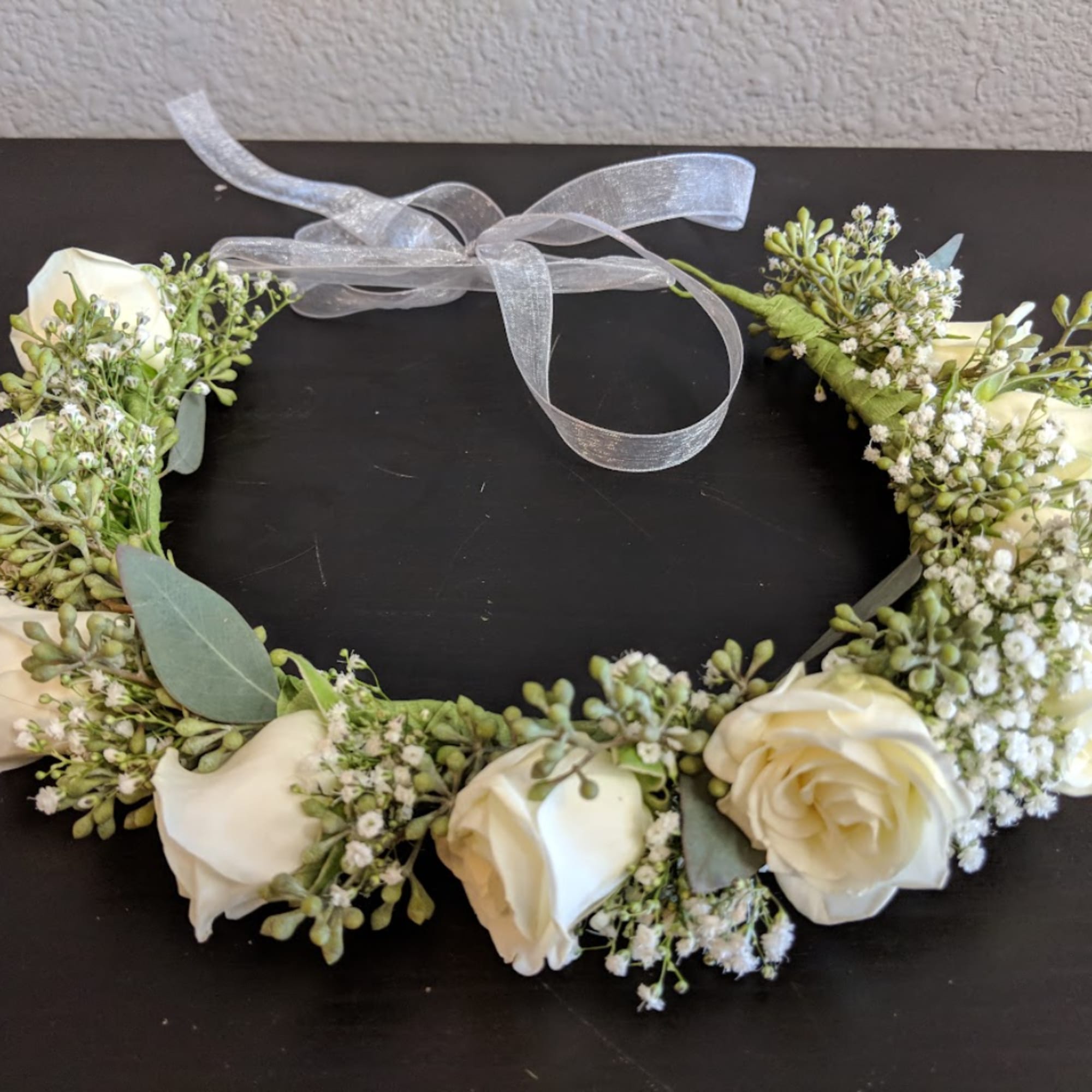 White rose floral wreath with a silver ribbon bow