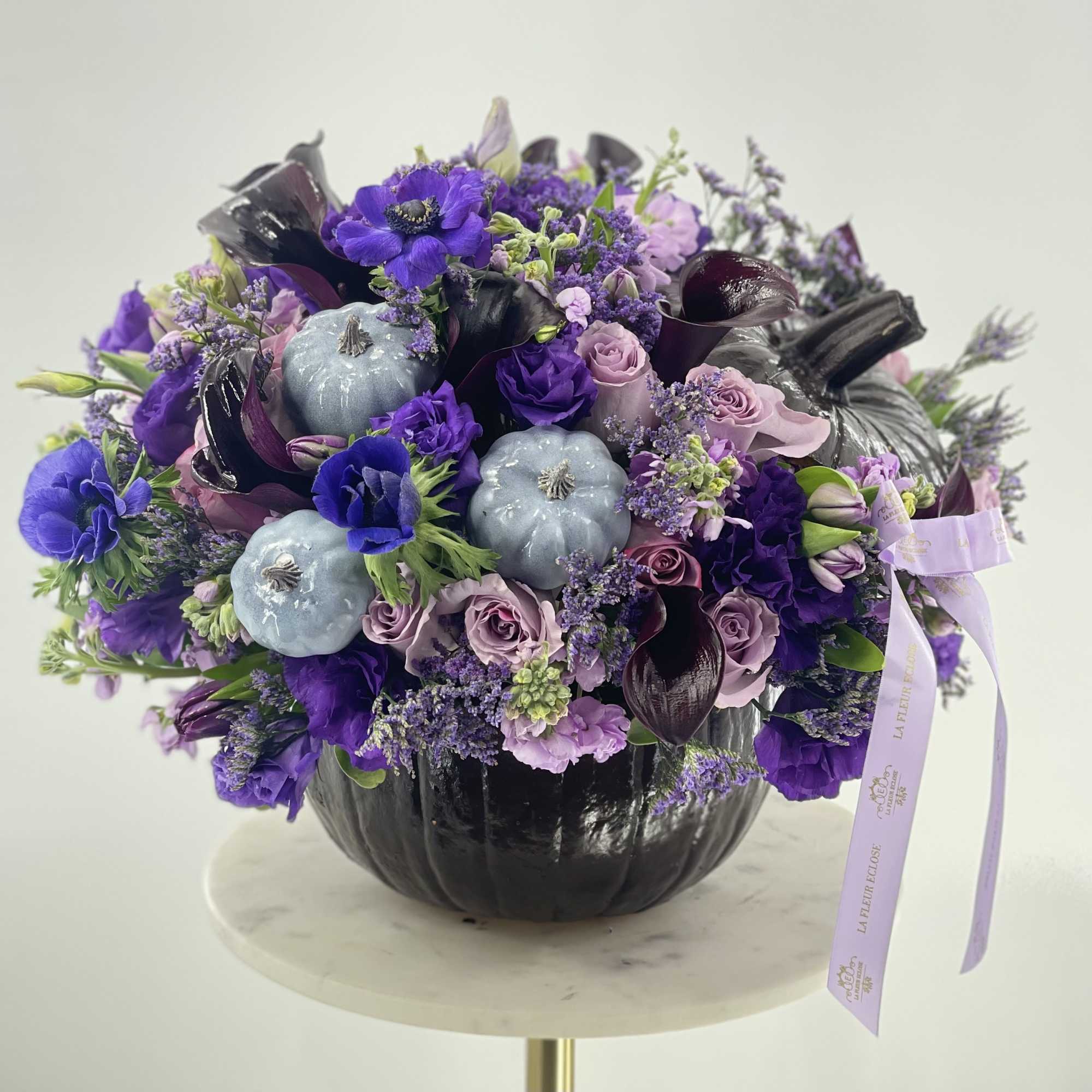 Beautiful dark brown pumpkin with the purple arrangement of fresh flowers!