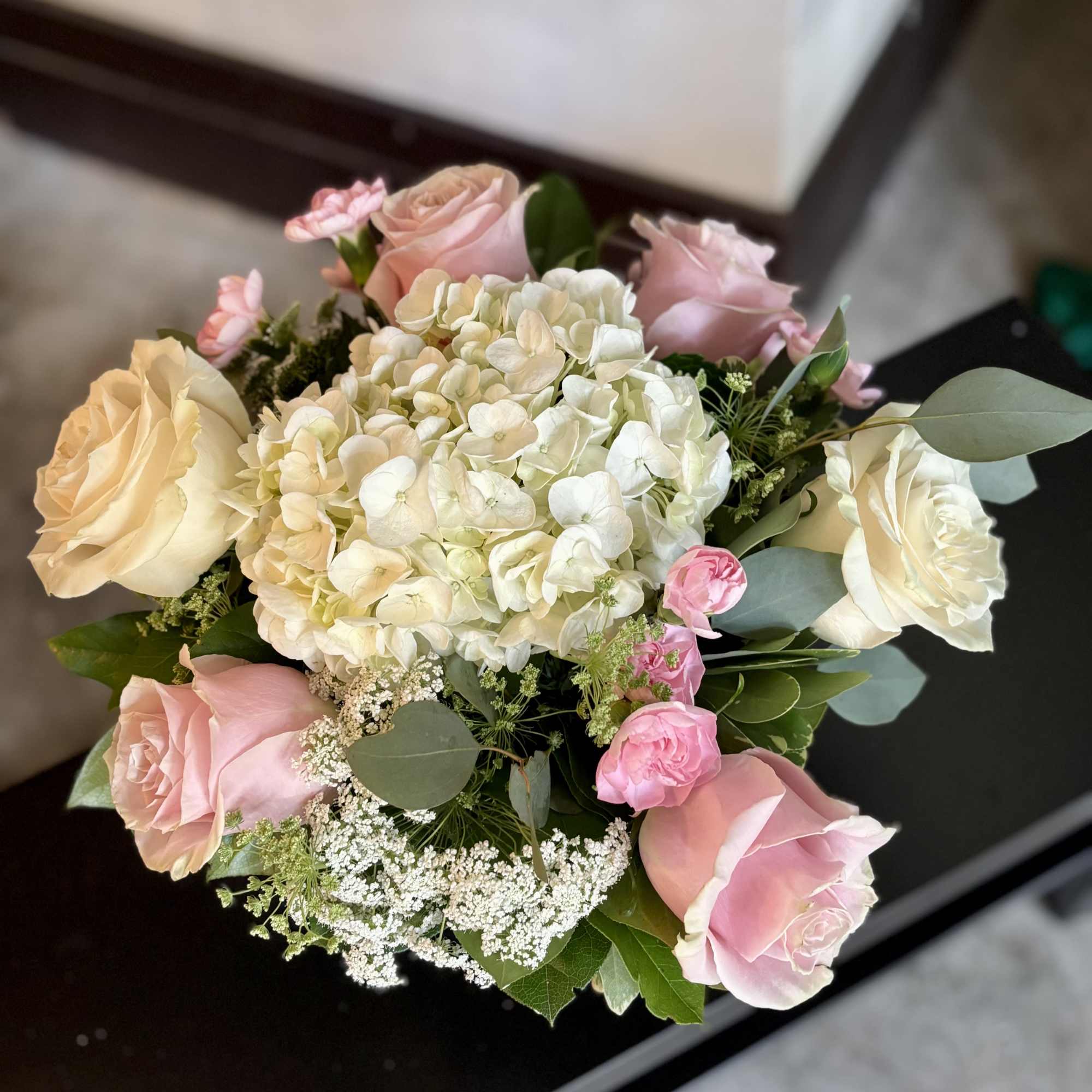 Bouquet of pink and cream roses with white hydrangea