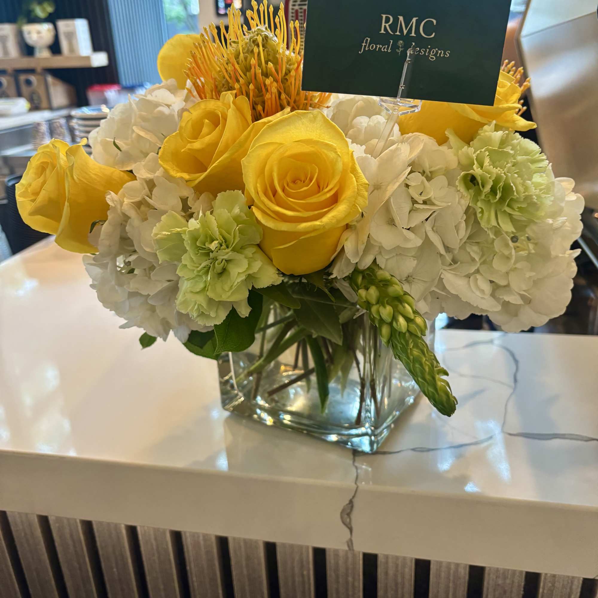 Yellow roses and white hydrangeas in a glass vase