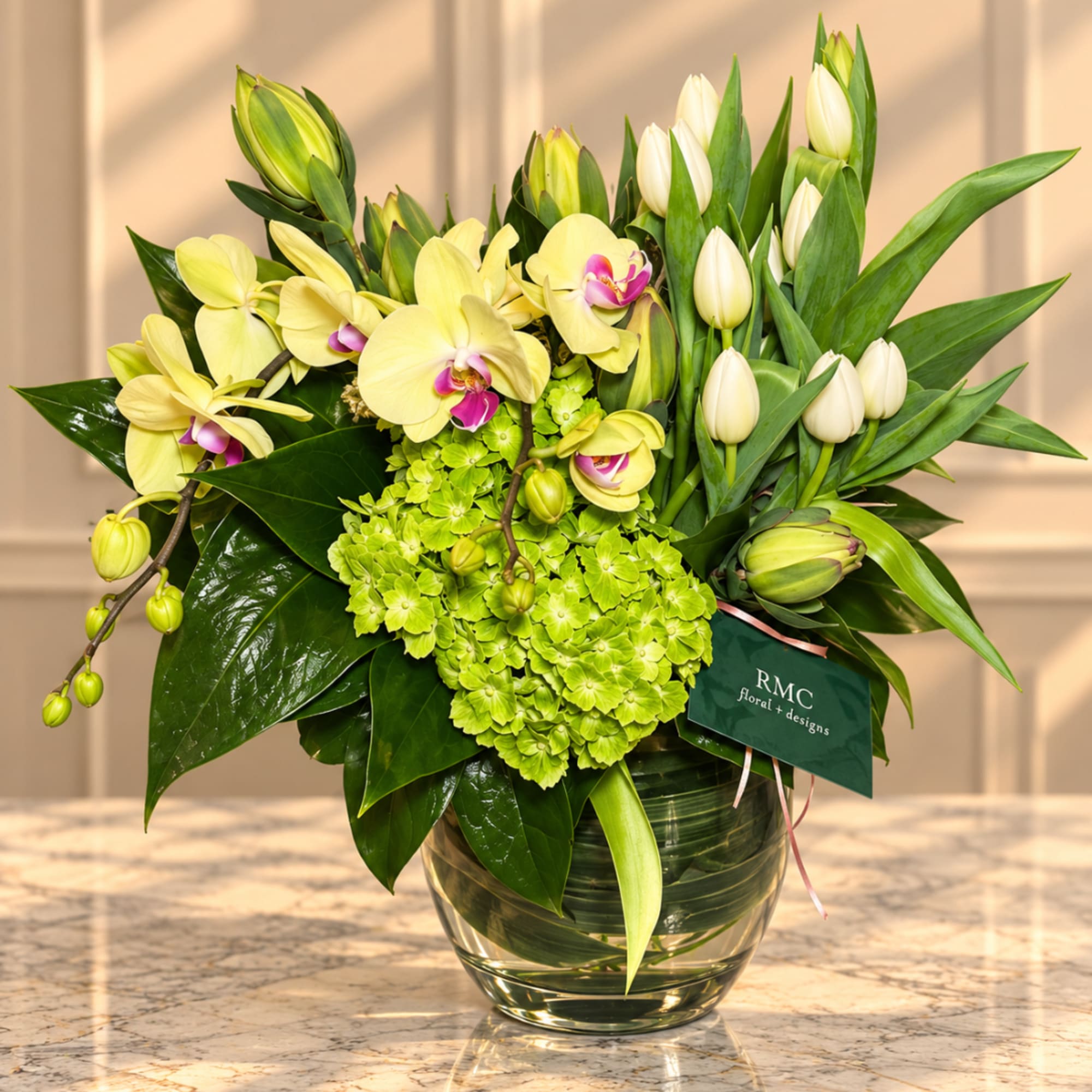 Yellow orchids and white tulips in a glass vase