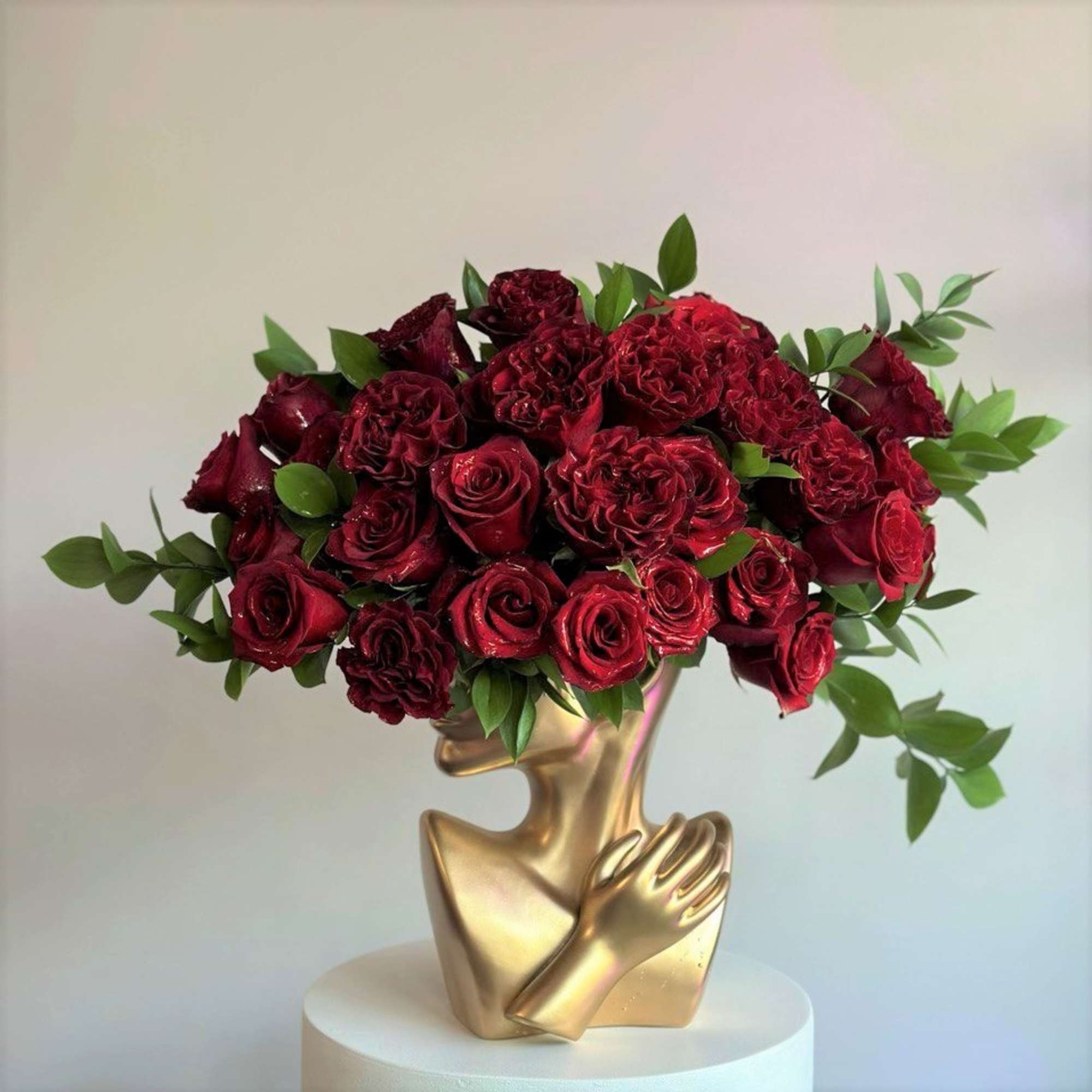 This striking red floral arrangement features lush red roses paired with fresh
