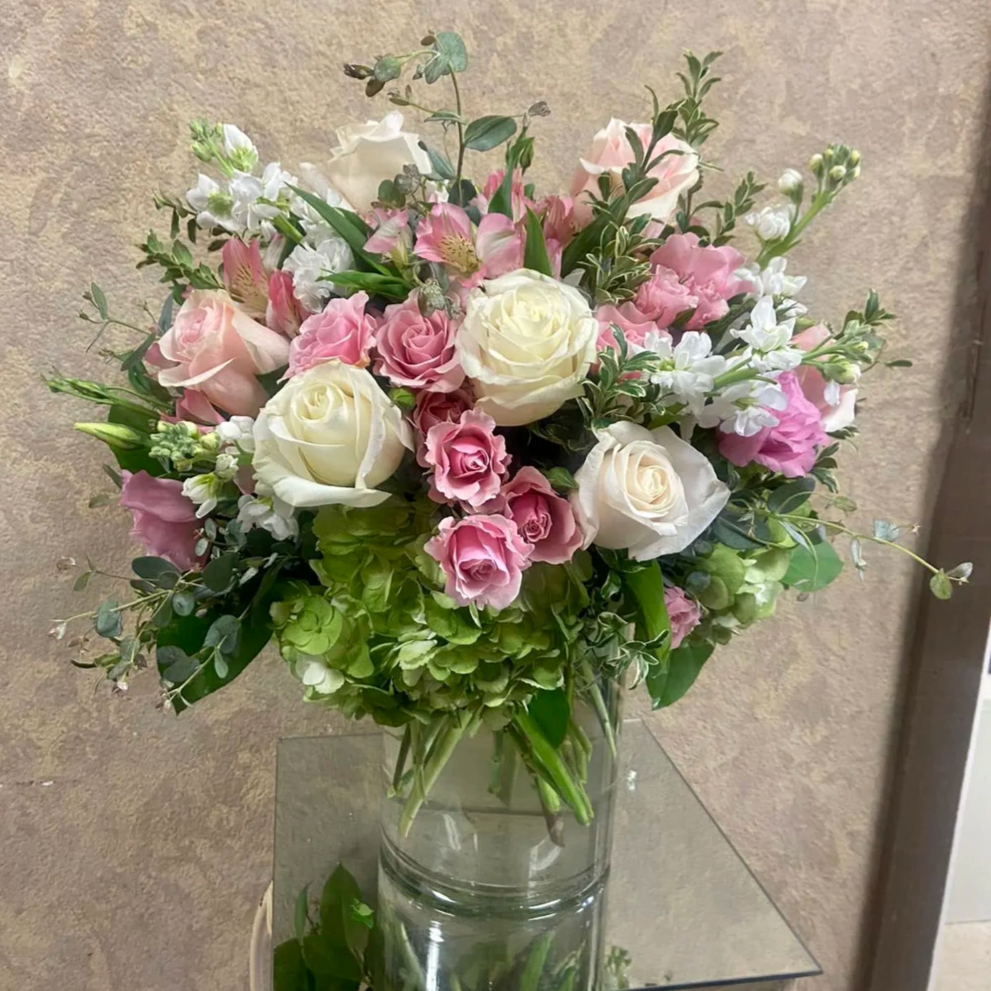 Pink and white rose bouquet in a clear glass vase