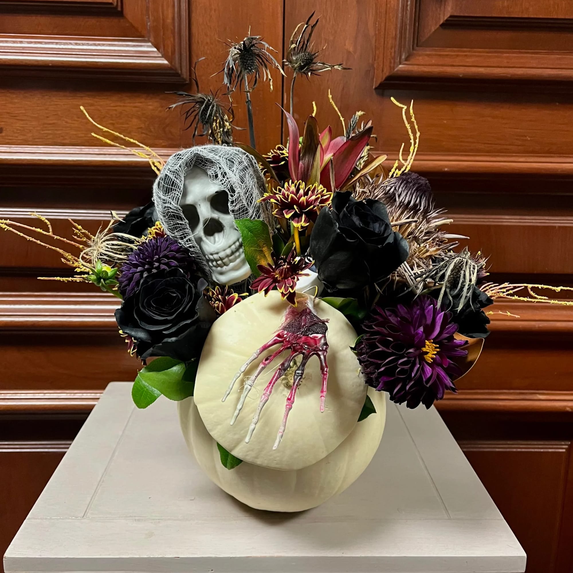 Halloween floral arrangement with a skull and pumpkin centerpiece