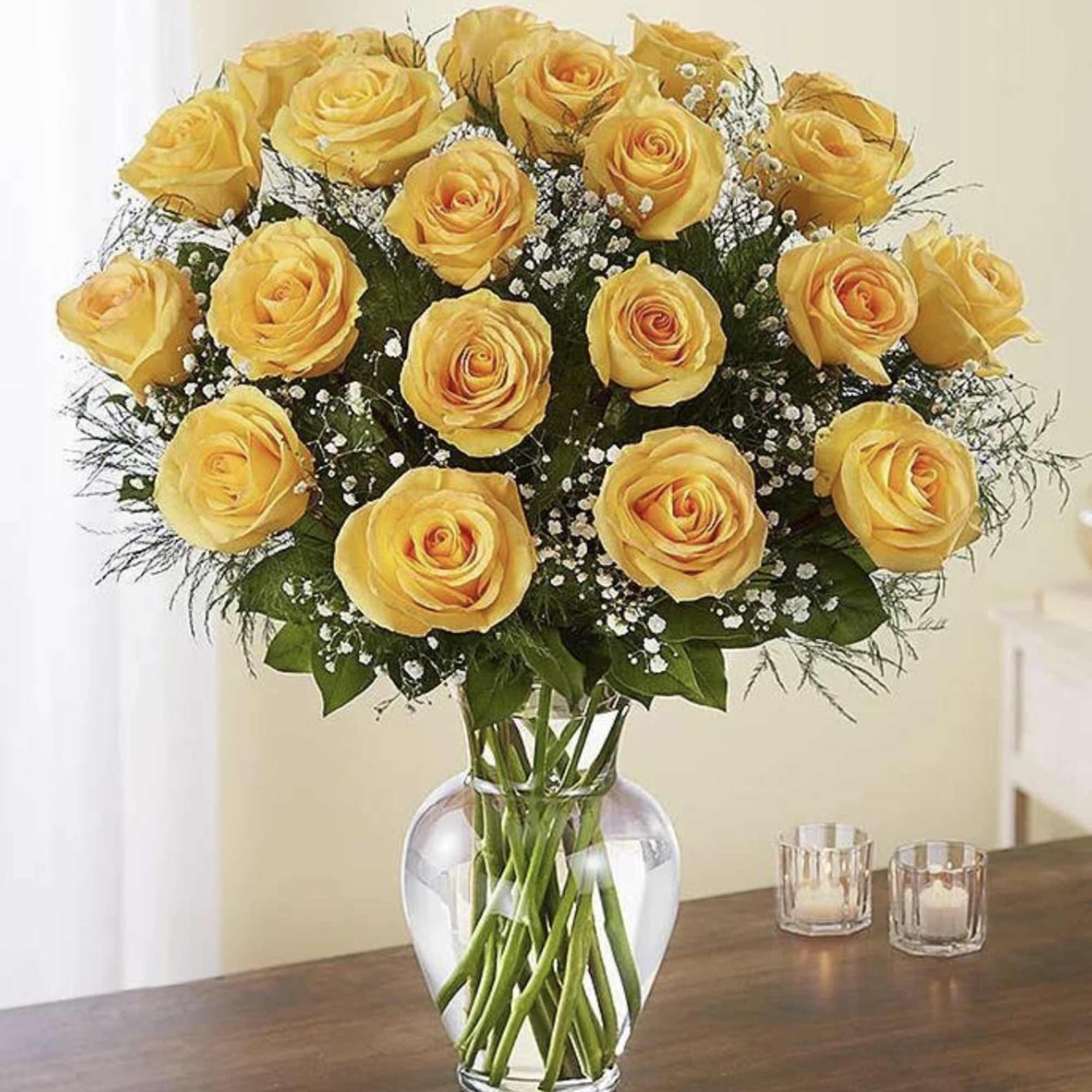 Yellow roses arranged in a clear glass vase on a table