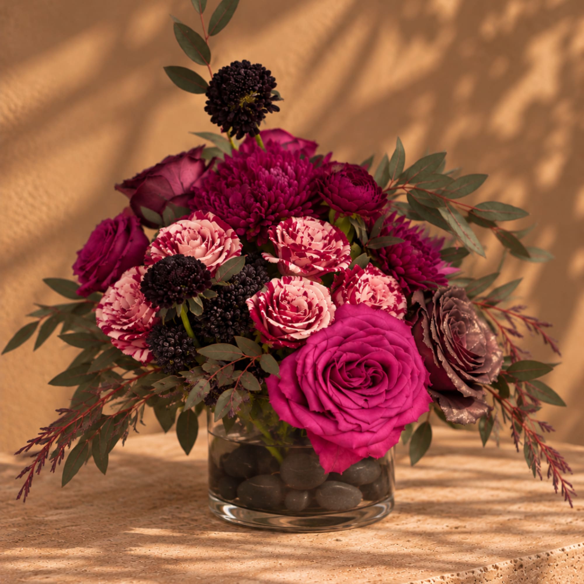 Pink and burgundy floral arrangement in a glass vase