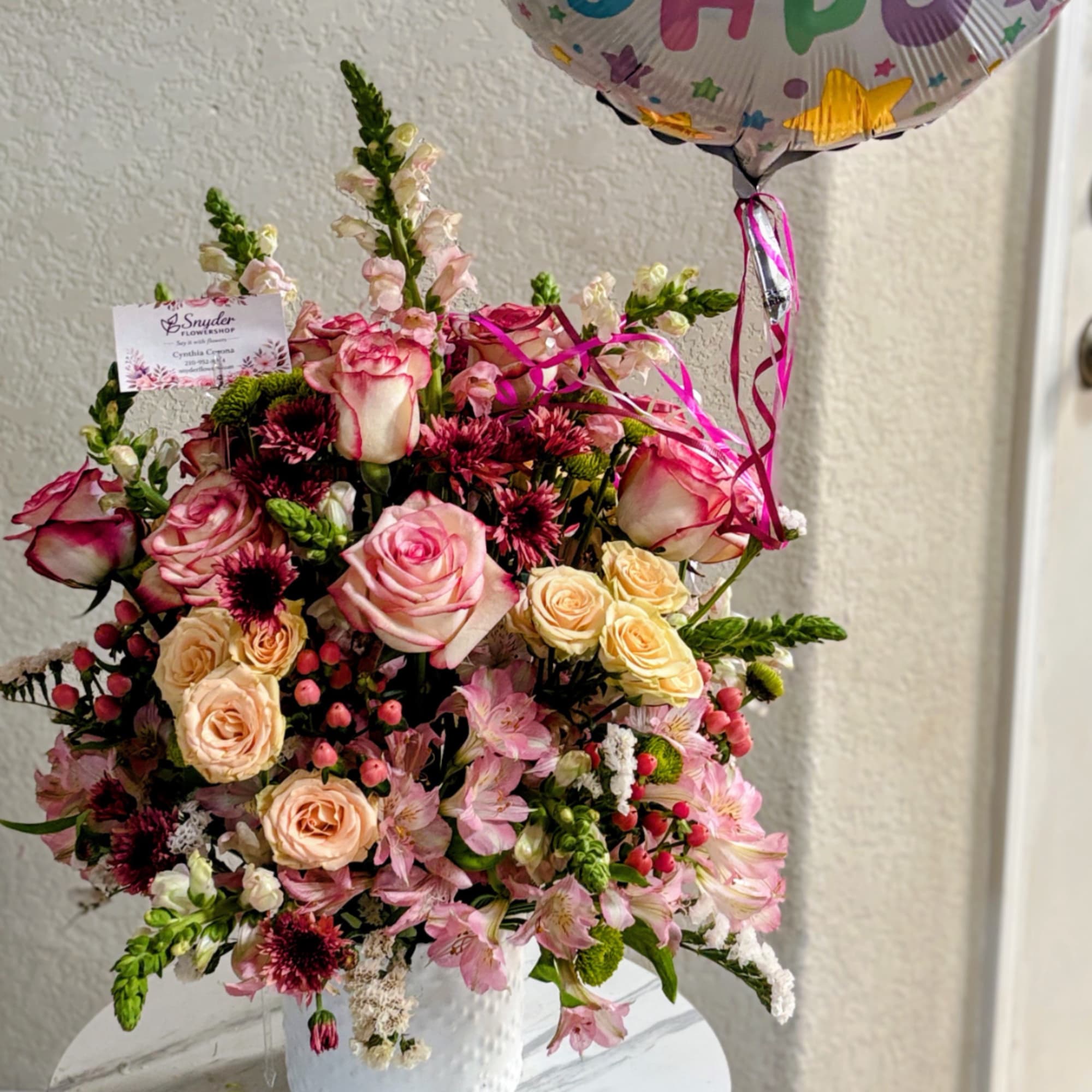 Pink and cream rose bouquet in a white vase with a birthday balloon