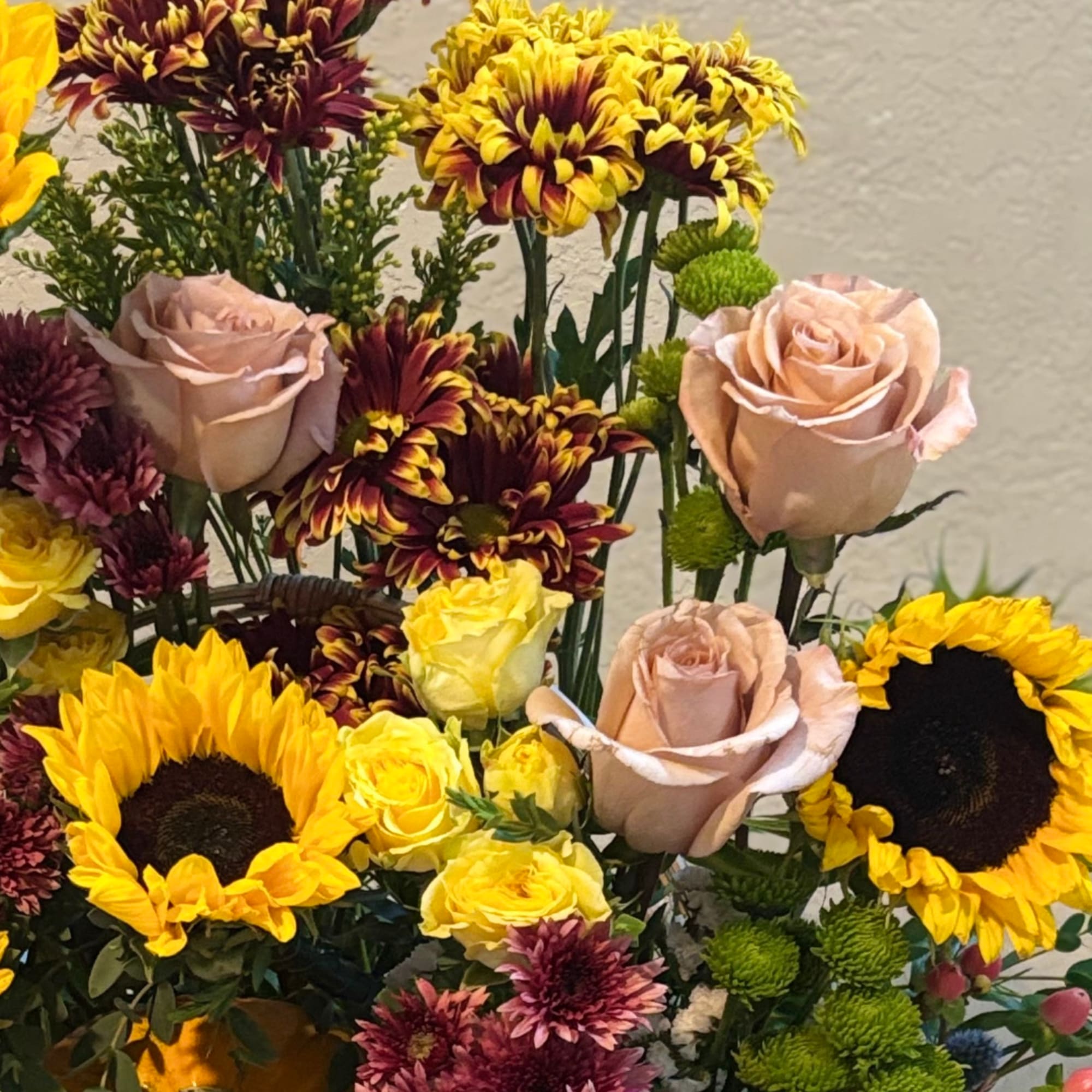 Bouquet with sunflowers, roses, and chrysanthemums in yellow, pink, and burgundy