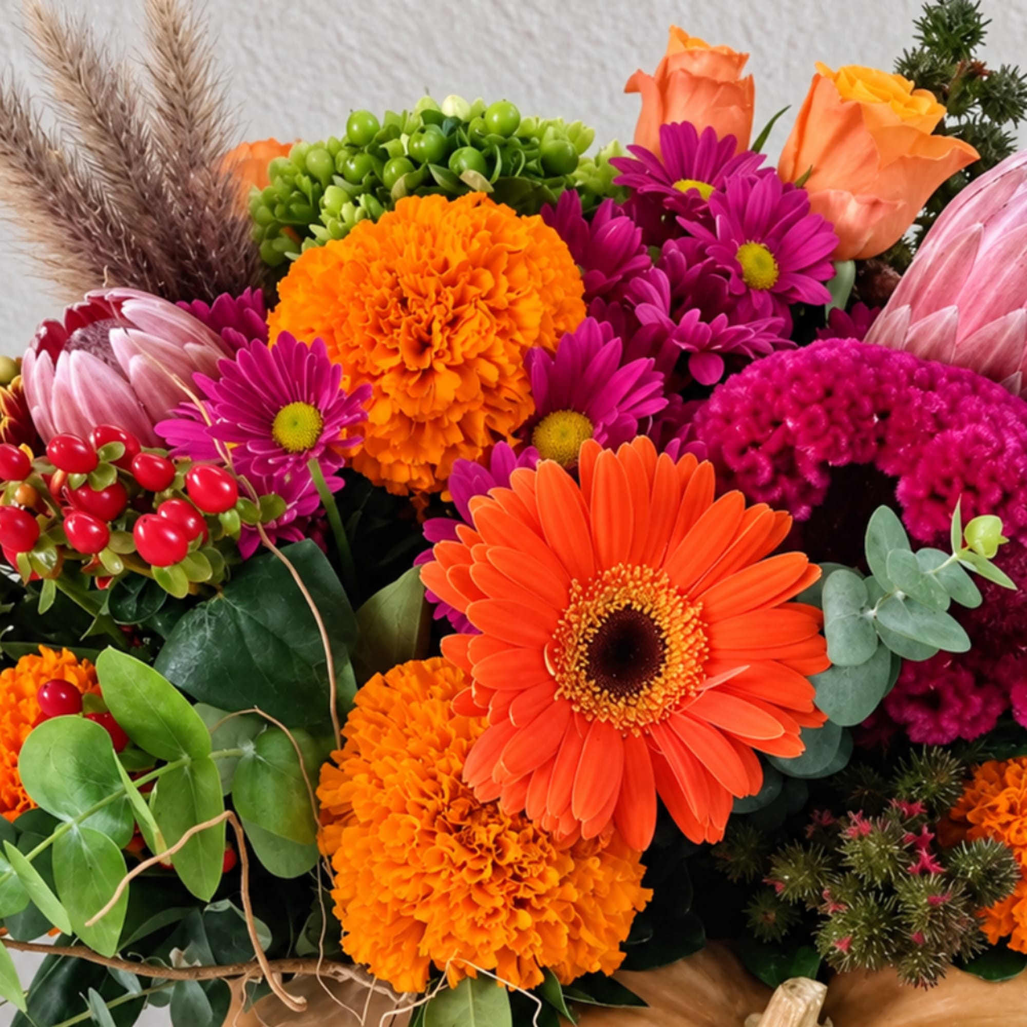 Bright mixed bouquet with orange gerbera daisies, marigolds, and magenta blooms